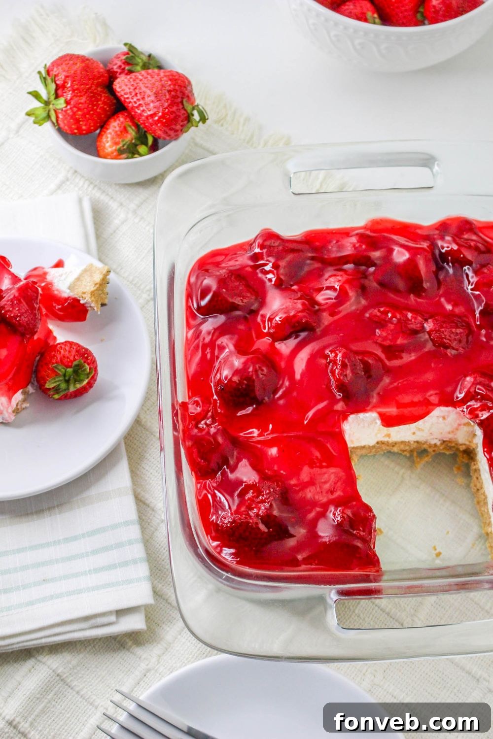 No Bake Strawberry Delight in pan with a slice taken out of it, and a plate with delight dessert on it 