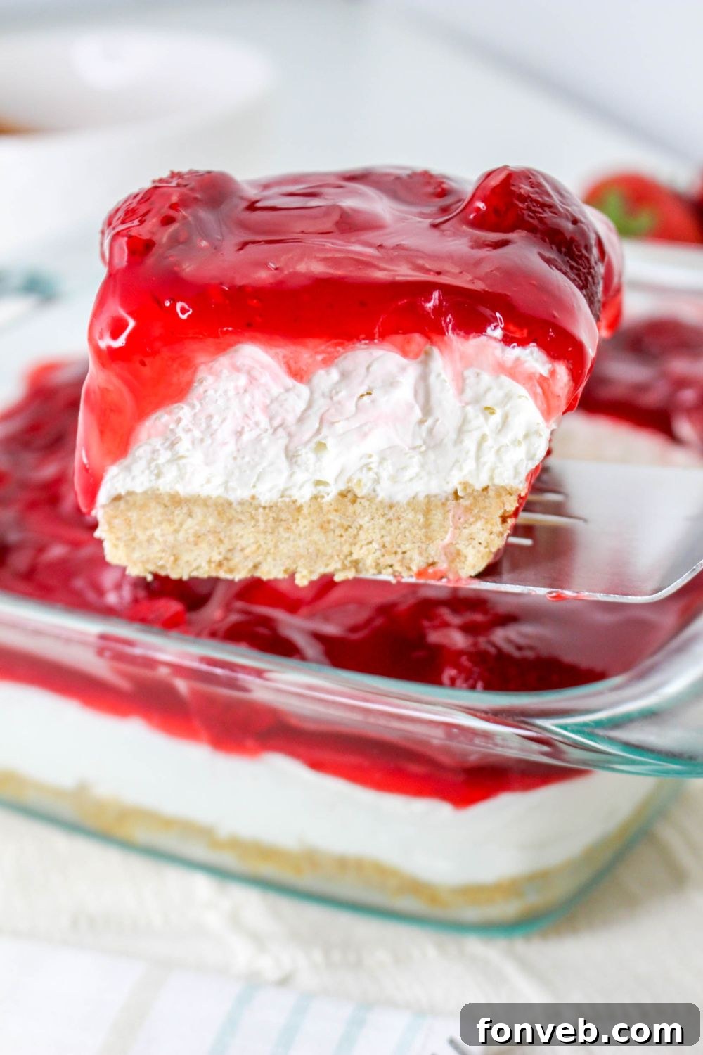 No Bake Strawberry Delight being lifted out of pan with spatula 