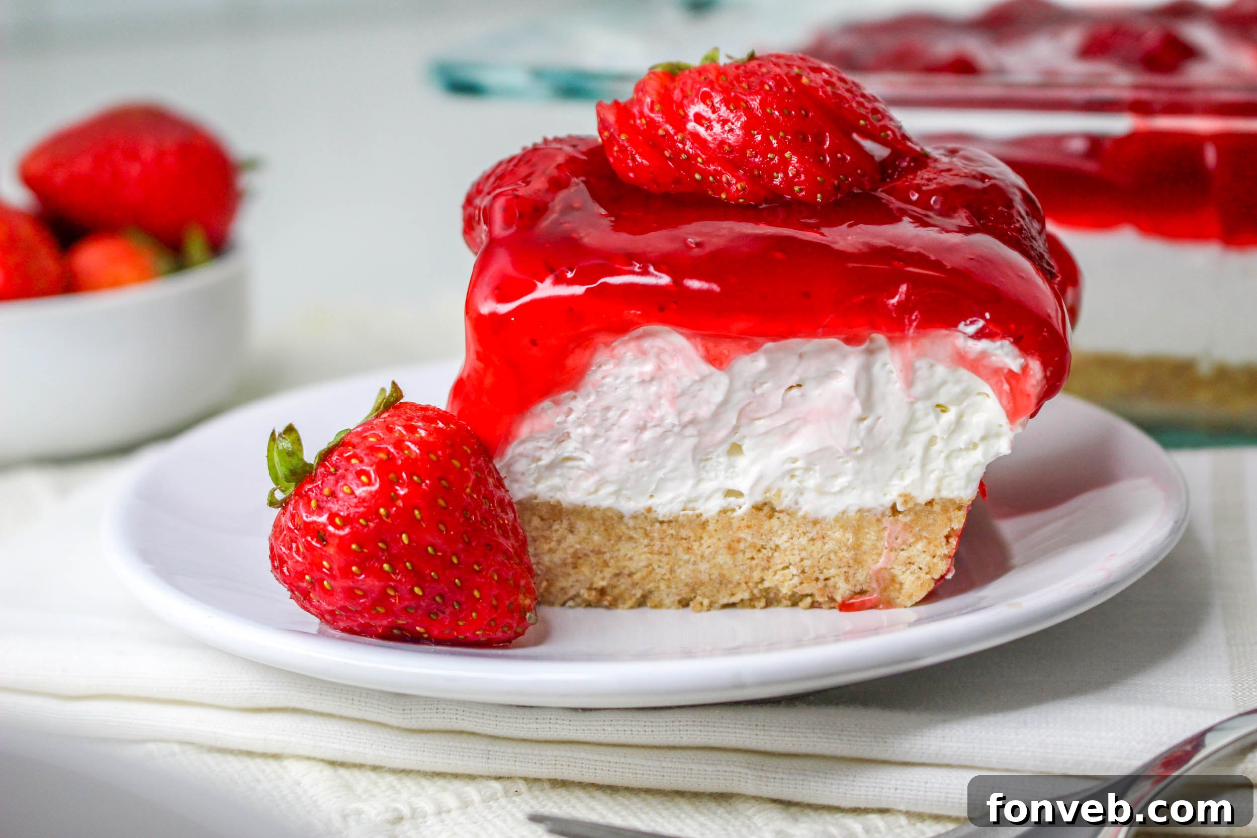 No Bake Strawberry Delight on a white plate topped with sliced strawberries 