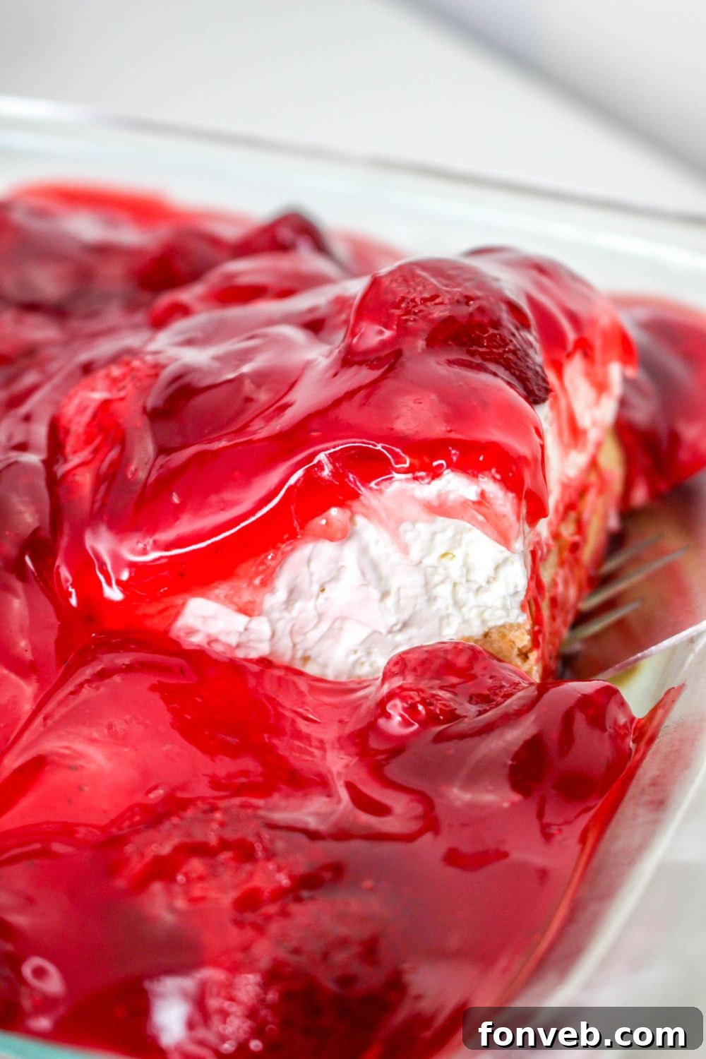 lifting a slice of No Bake Strawberry Delight out of pan 