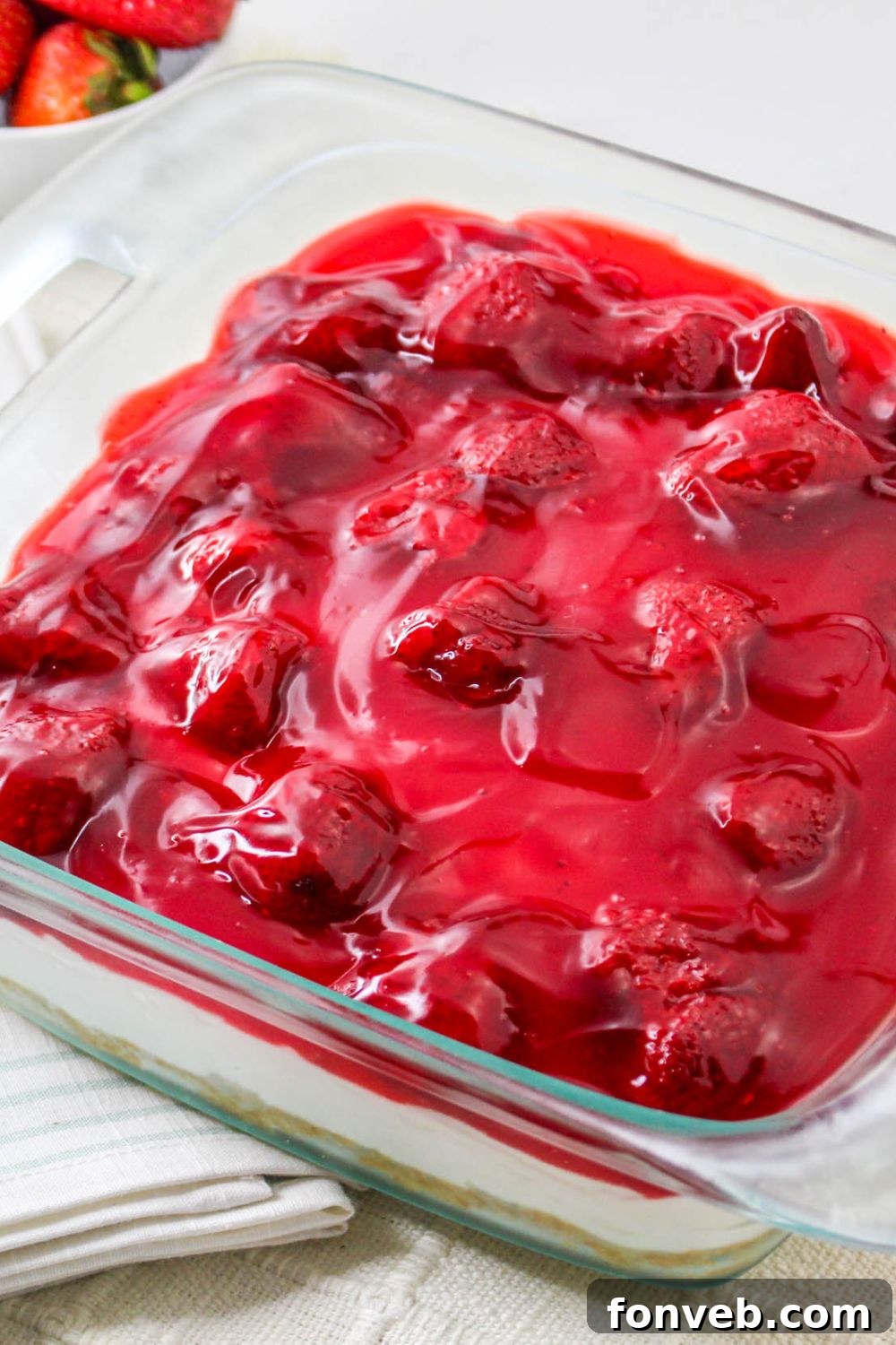 side view of No Bake Strawberry Delight in a glass pan on table 
