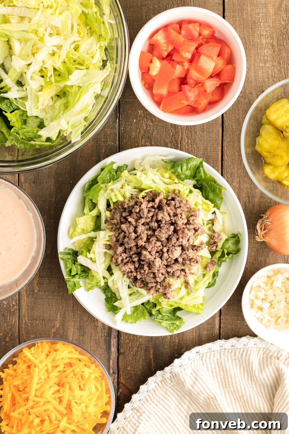 Big Mac Makeover Salad 7 A plate featuring crisp lettuce and savory ground beef, representing an early stage of assembling the Big Mac Salad on a wooden table.