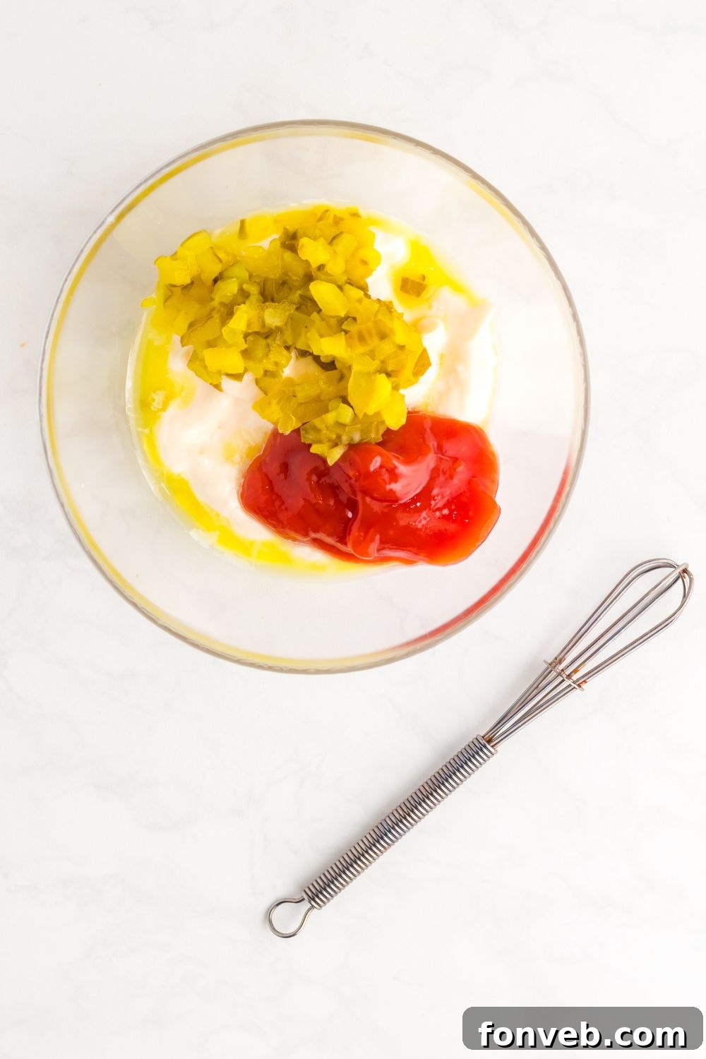 Big Mac Makeover Salad 9 All the essential ingredients for the homemade Big Mac Salad sauce are gathered in a clear glass bowl, with a whisk resting beside it.