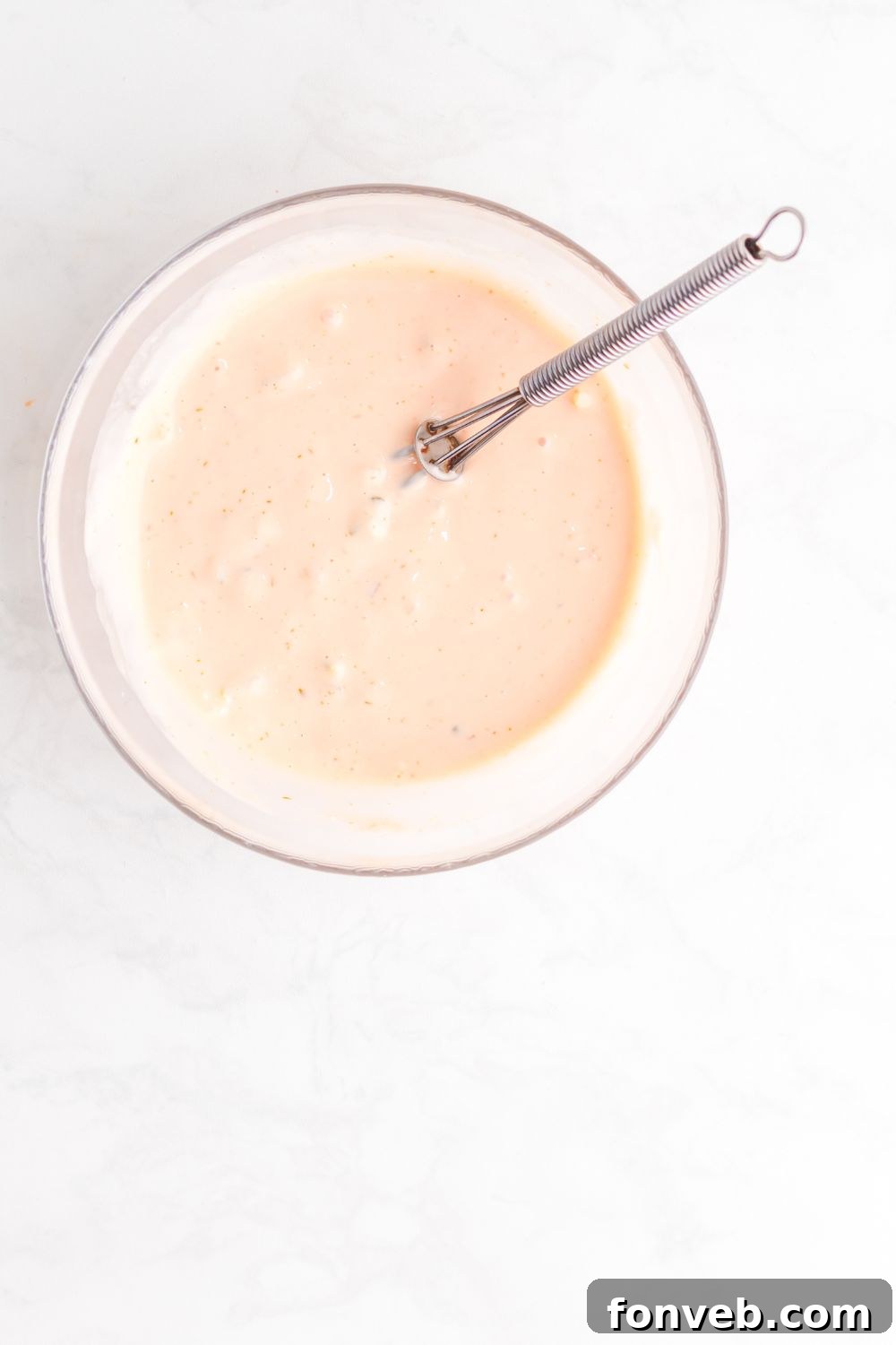 Big Mac Makeover Salad 10 The Big Mac Salad dressing, perfectly mixed and creamy, sits in a clear glass bowl with a whisk, ready to be drizzled over the salad.