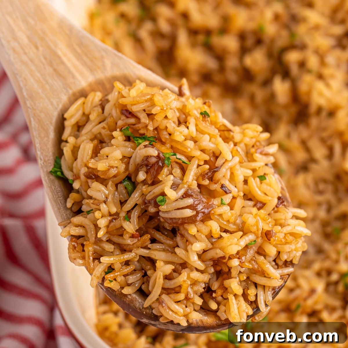 Stick of Butter Rice in pan with a wooden spoonful on table