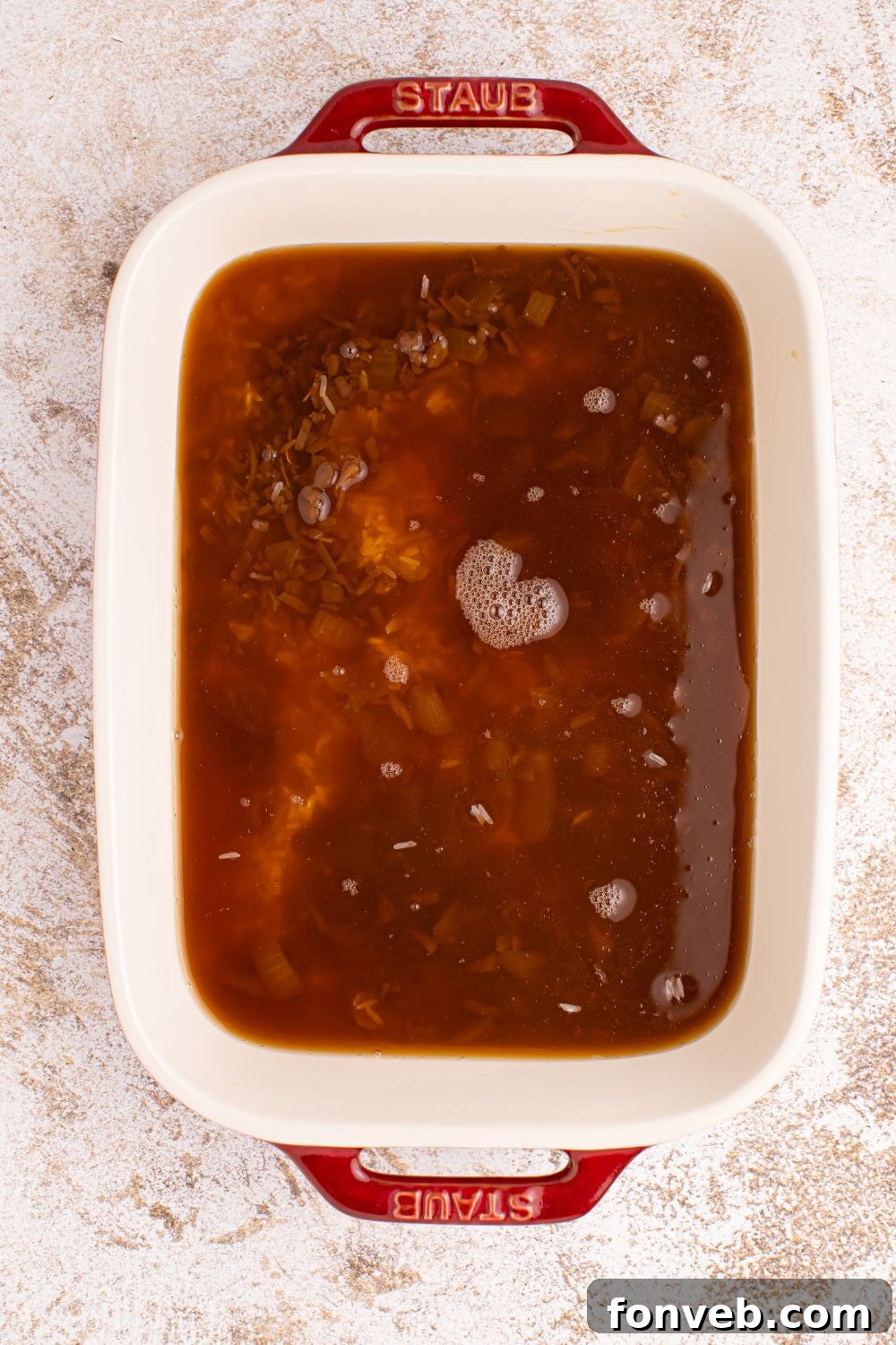 Stick of Butter Rice mixture in a casserole dish with rice and broth and soup 