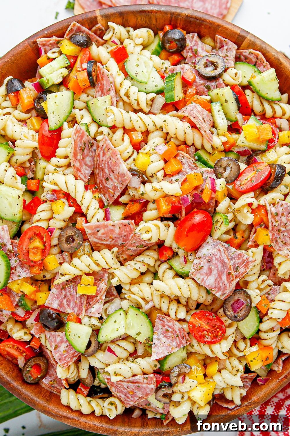 Overhead shot of Summer Pasta Salad in a wooden bowl, presented on a table.
