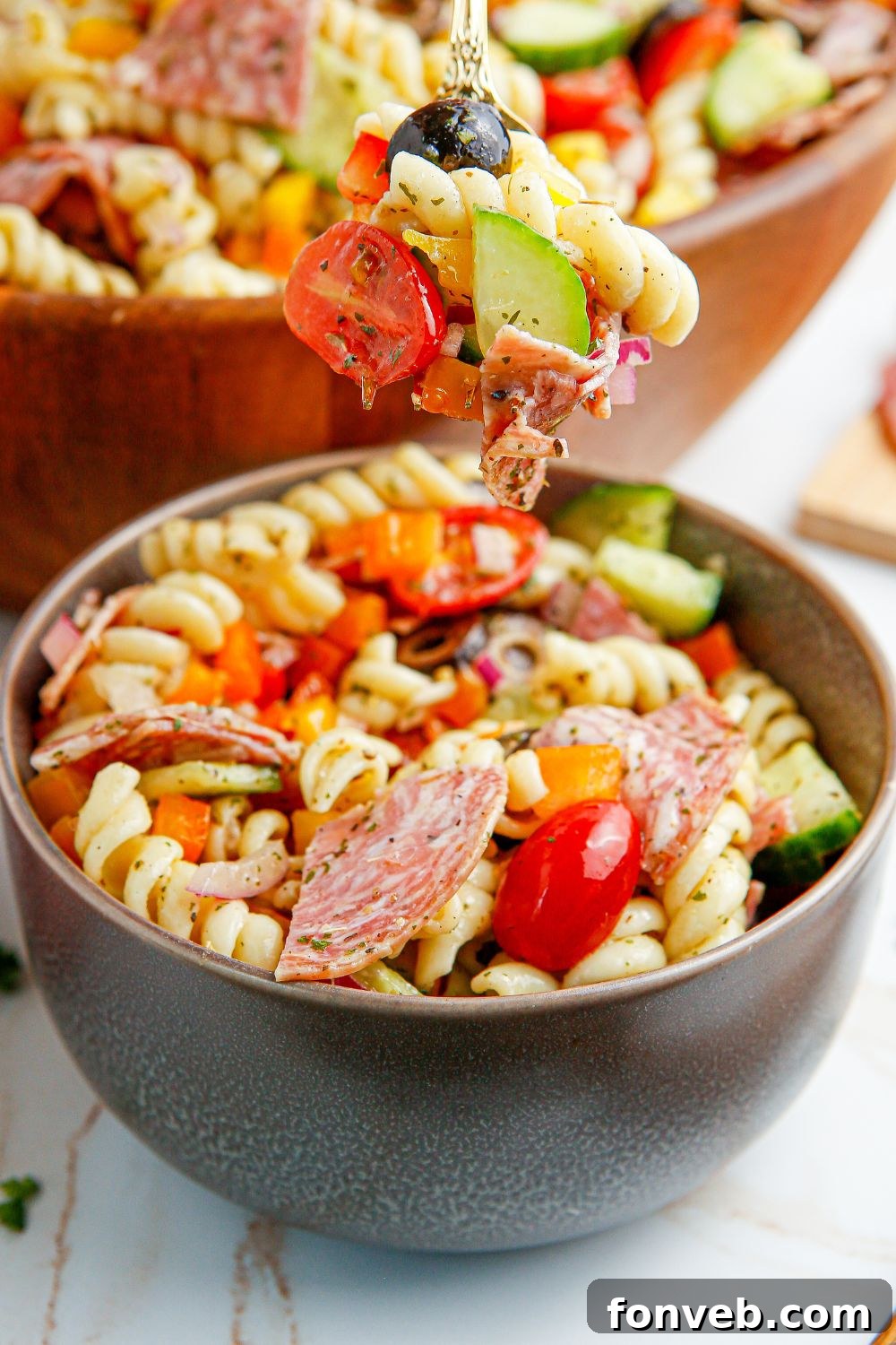 Summer Pasta Salad in a bowl, with a fork holding some of the salad.