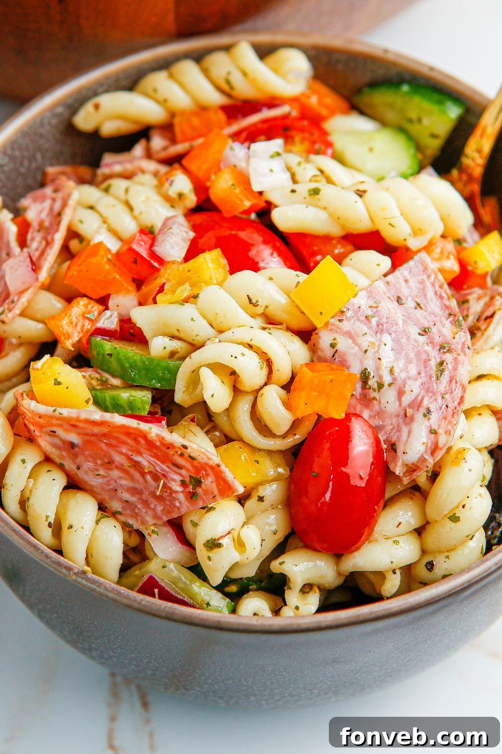 Close-up of Summer Pasta Salad in a bowl, highlighting the fresh, crisp vegetables and salami pieces.