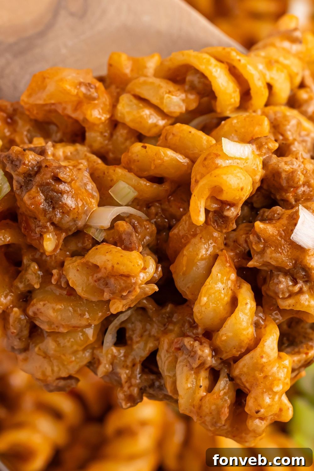 A close-up shot of the creamy, cheesy pasta texture within a pan of Taco Macaroni and Cheese.
