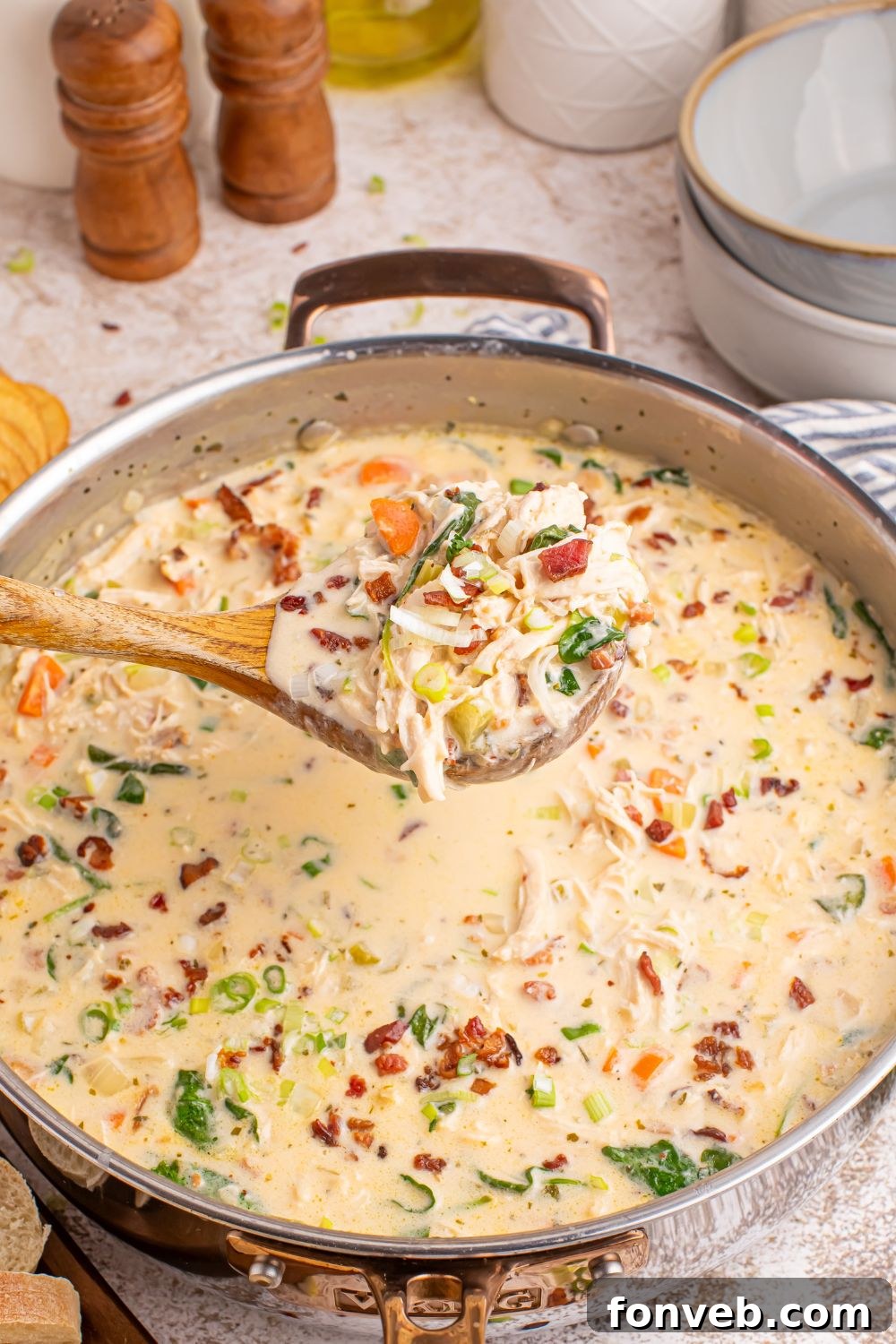 A ladle gracefully lifting a portion of hot, creamy Crack Chicken Soup from a simmering pan