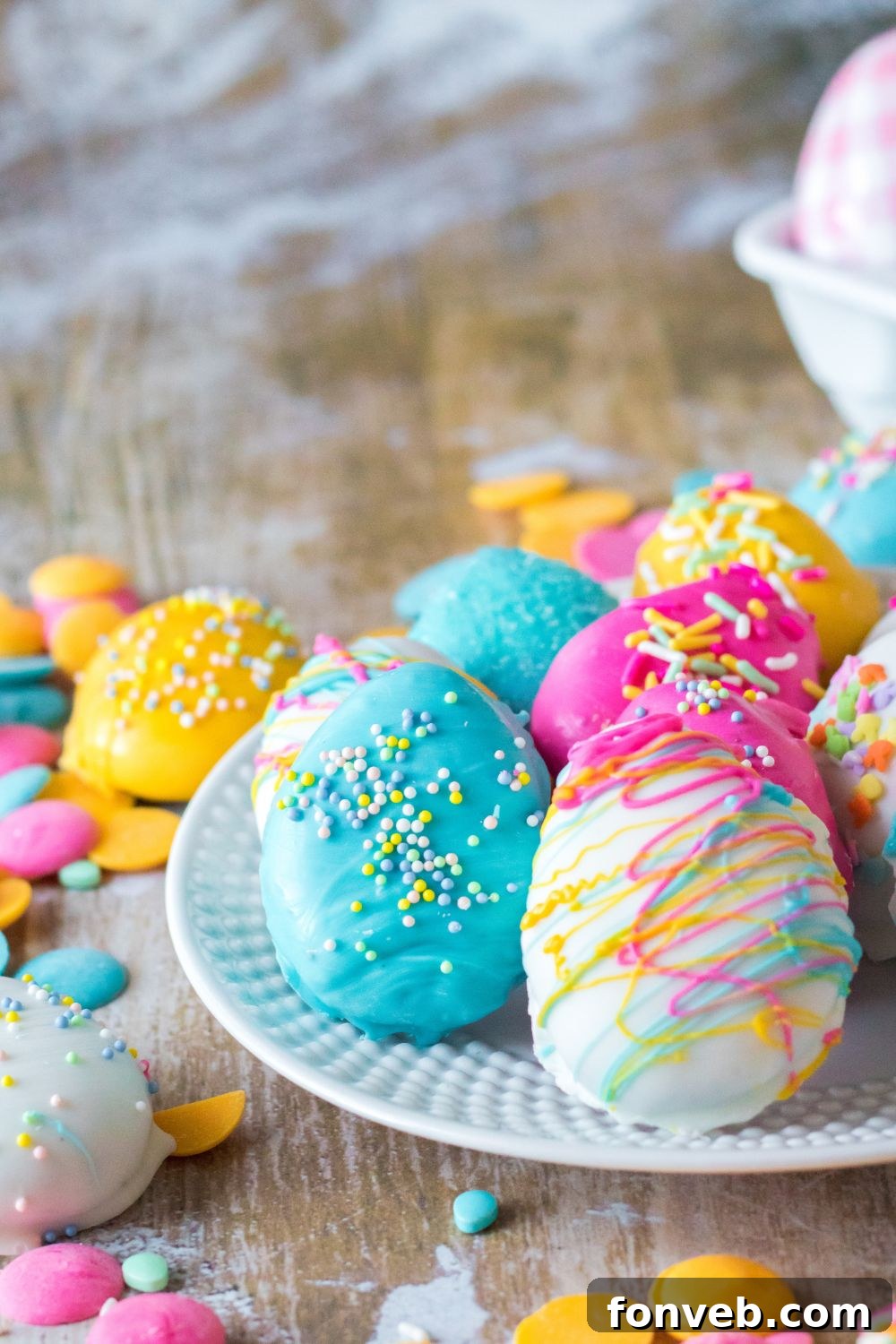 Festive Easter Egg Oreo Truffles 14 A festive arrangement of Easter Egg Oreo Truffles on a white plate, surrounded by scattered sprinkles and charming Easter decor on a table, creating a delightful holiday scene.