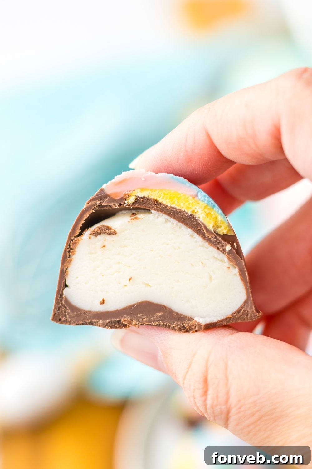 Fluffy Easter Delights 10 Easter Marshmallow Egg cut in half and showing the filling while being held in a hand