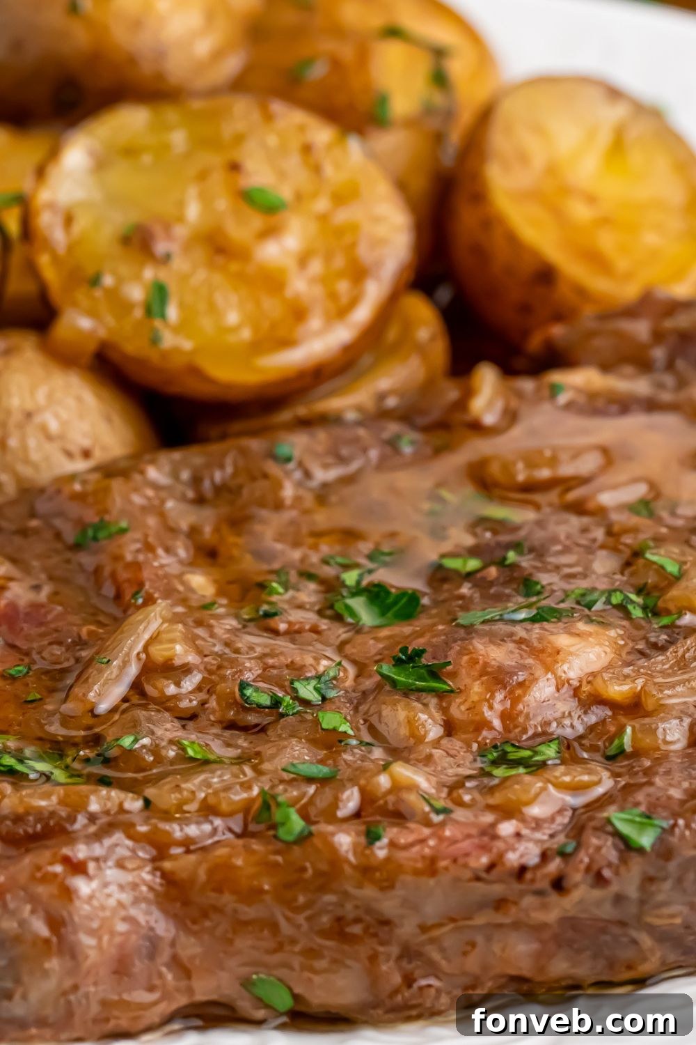 Close-up of perfectly cooked steak and potatoes on a plate, highlighting the texture and rich sauce