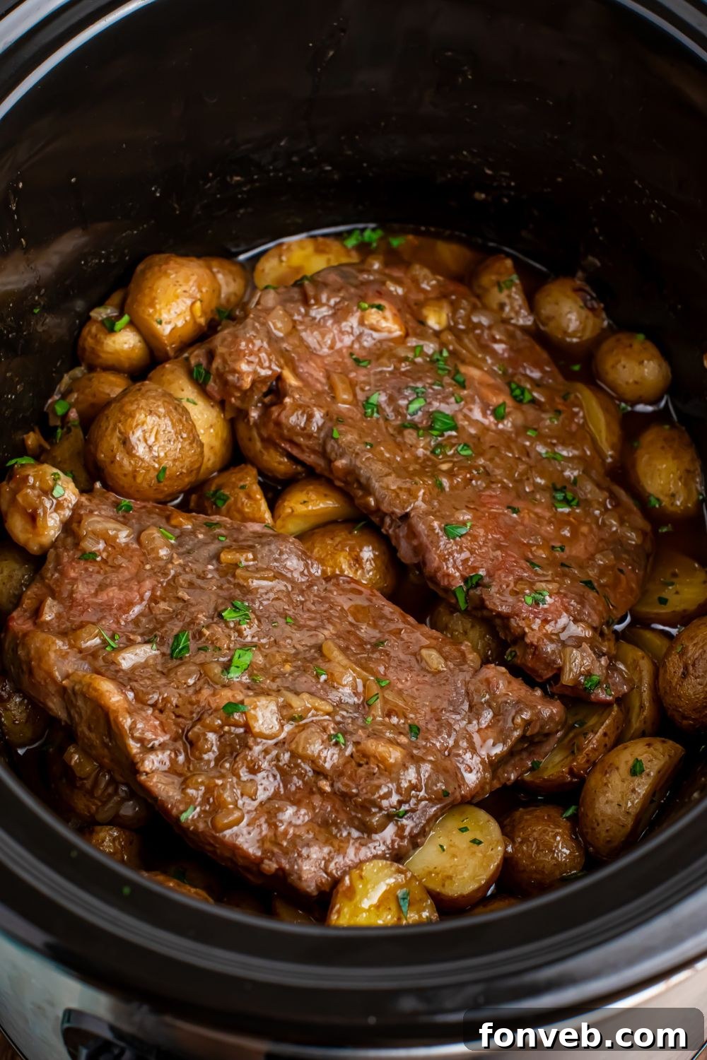 Crock Pot Steak and Potatoes in a slow cooker, sitting on a kitchen table