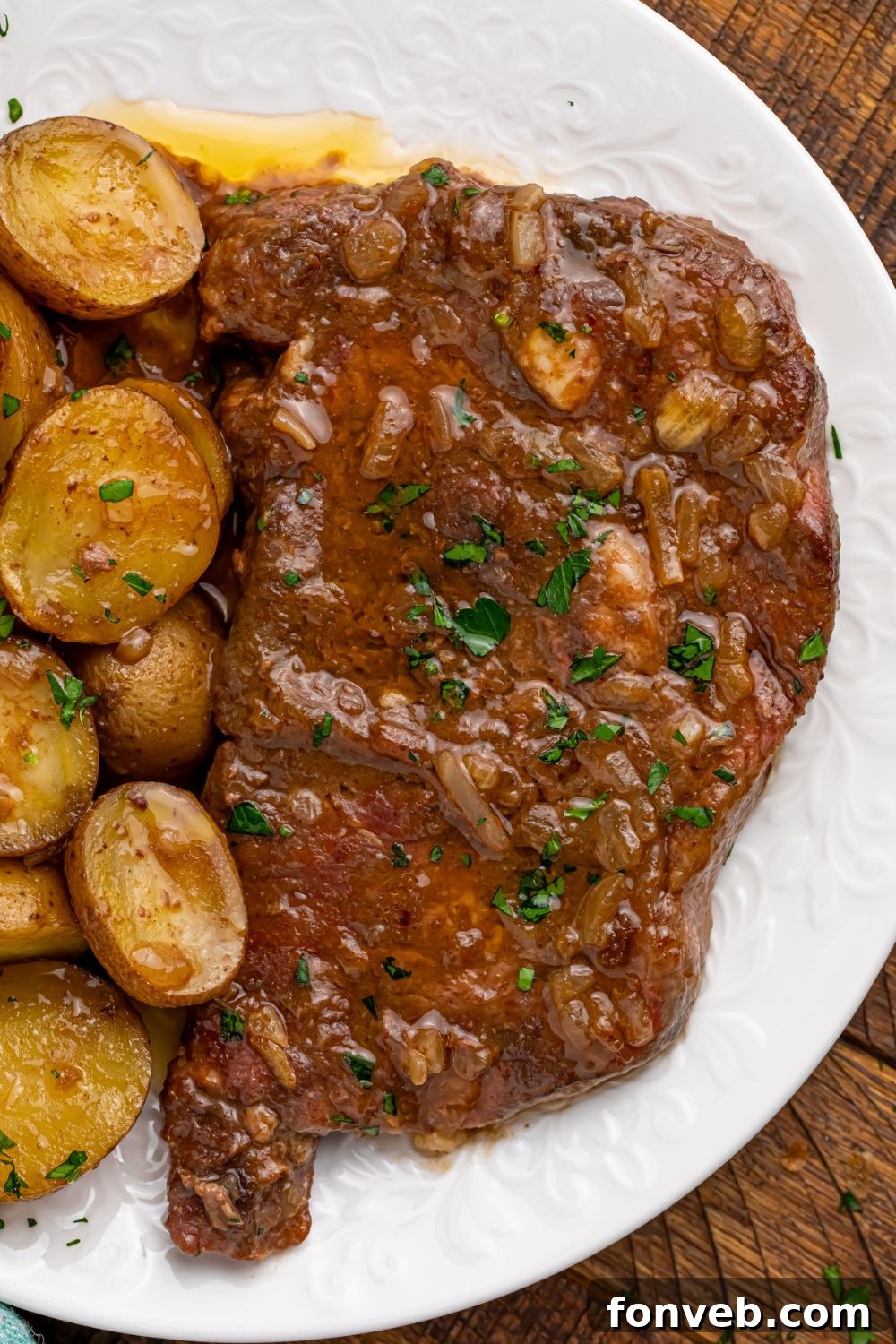 A close-up shot of Crock Pot Steak and Potatoes served on a plate, highlighting the tender steak and golden potatoes