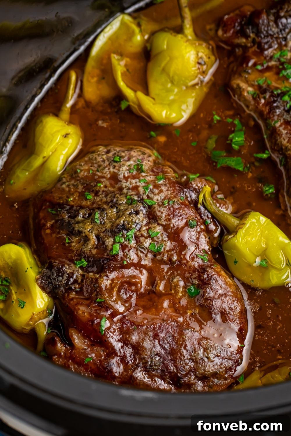 Slow Cooker Mississippi Ribeye Steaks in pot with a close up with peppers around it