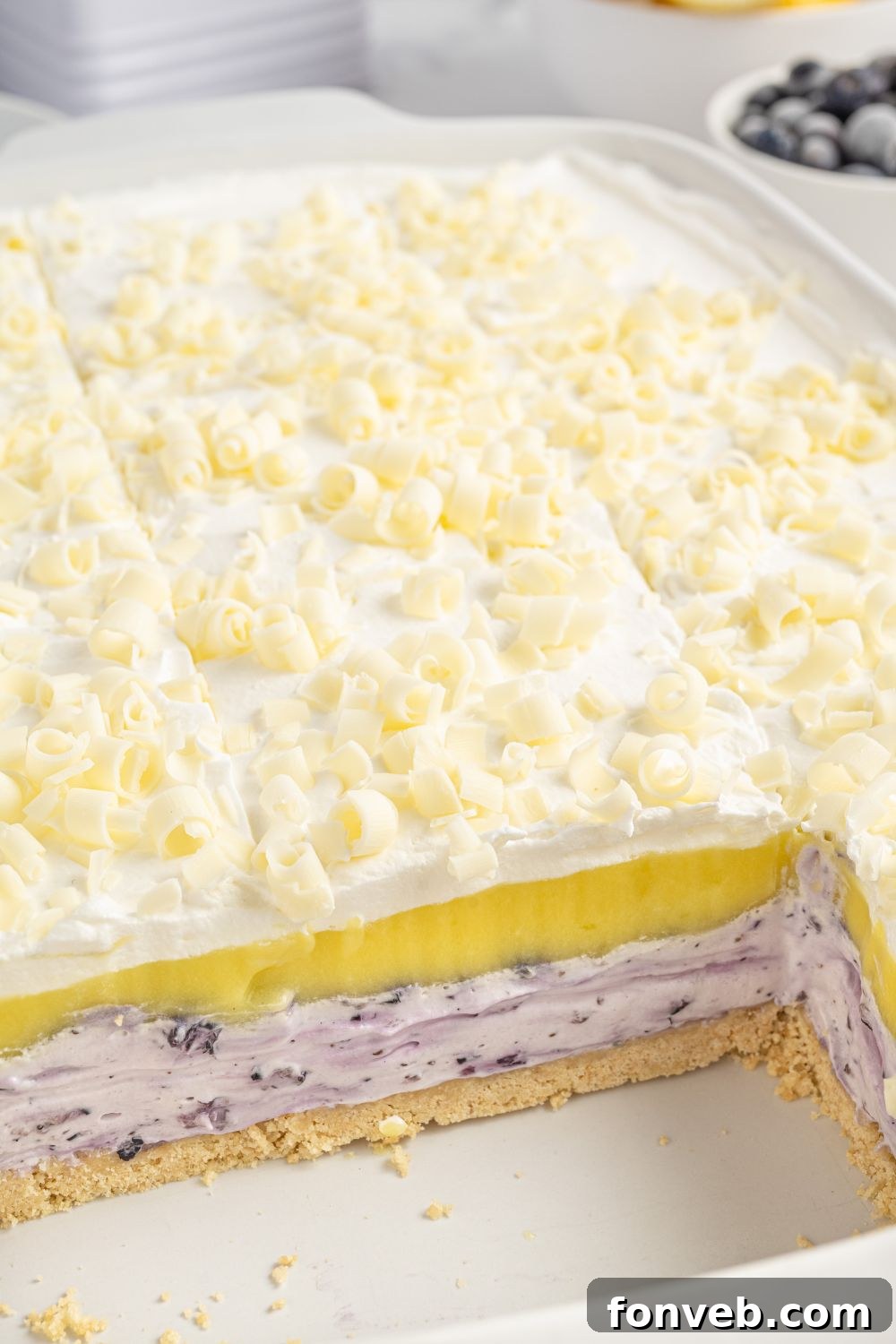 Lemon Blueberry Lush in a pan with a few slices removed, clearly showing the beautifully defined layers within the dessert.