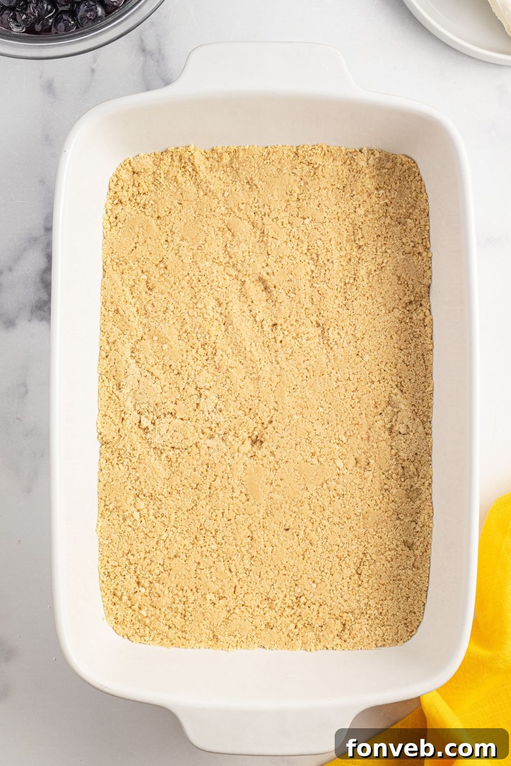 Golden Oreo crust pressed firmly into a 9x13 inch pan, ready for the next layers of the Lemon Blueberry Lush.