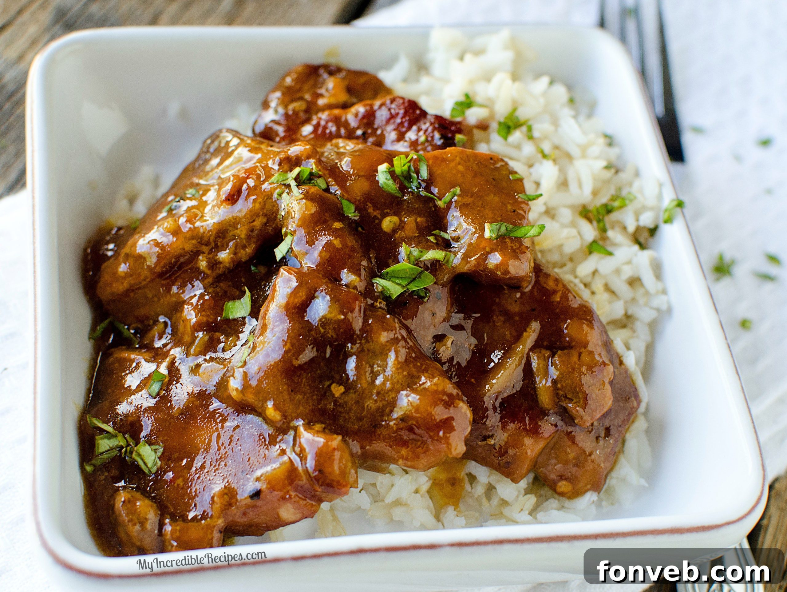 Tender Garlic Ginger Slow Cooker Pork 2 Finished Slow Cooker Garlic Ginger Pork over rice, garnished with fresh herbs.