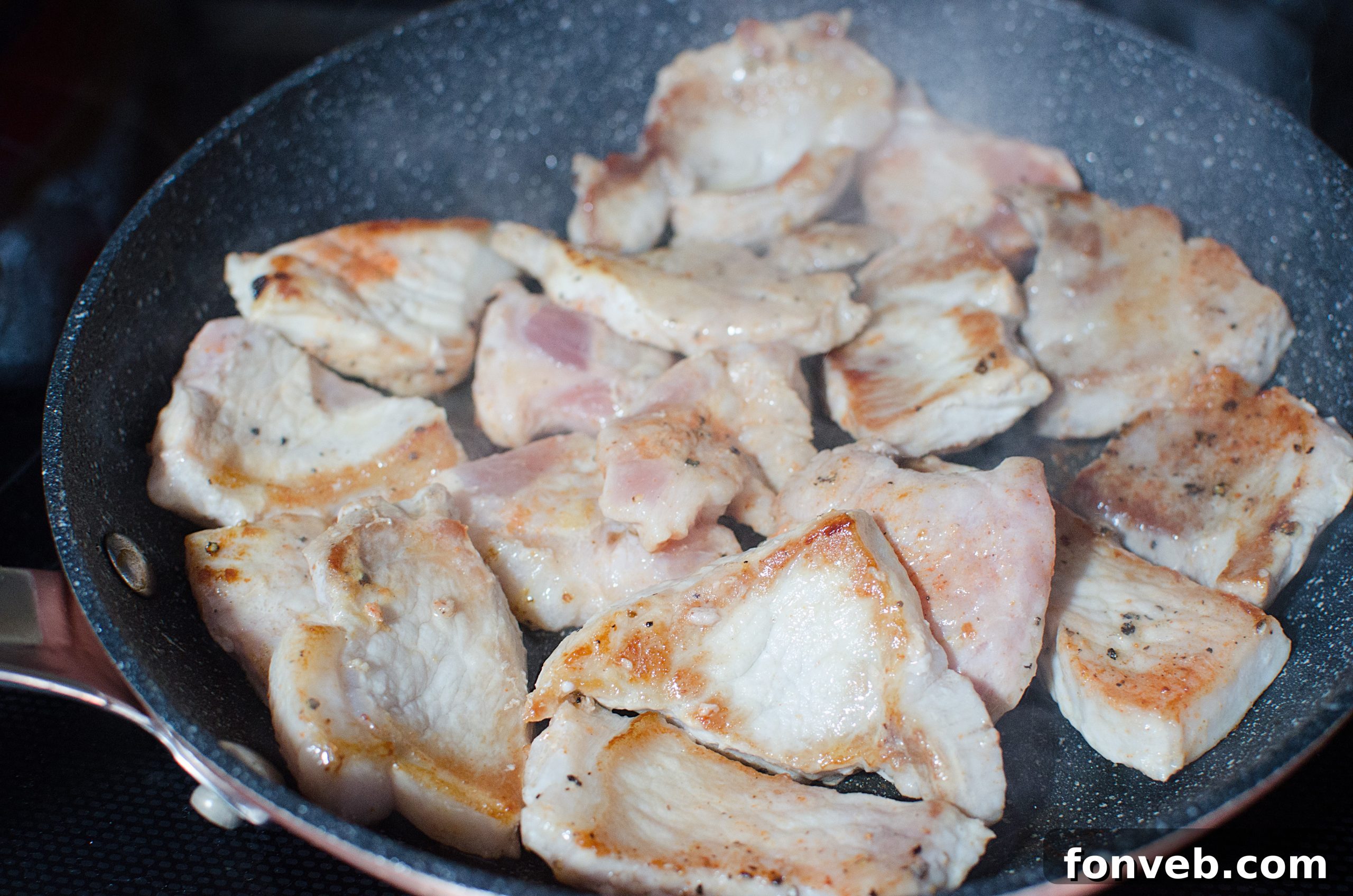 Tender Garlic Ginger Slow Cooker Pork 3 Pork pieces being caramelized in a hot pan before slow cooking.