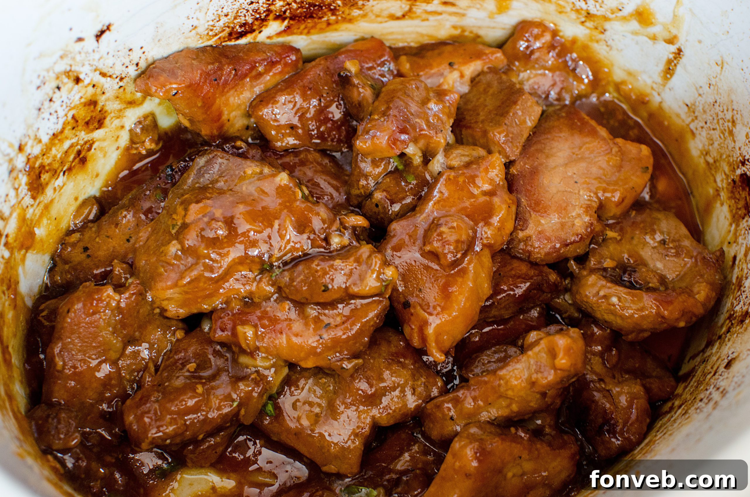 Tender Garlic Ginger Slow Cooker Pork 6 Close-up of tender garlic ginger pork simmering in the crock pot sauce.