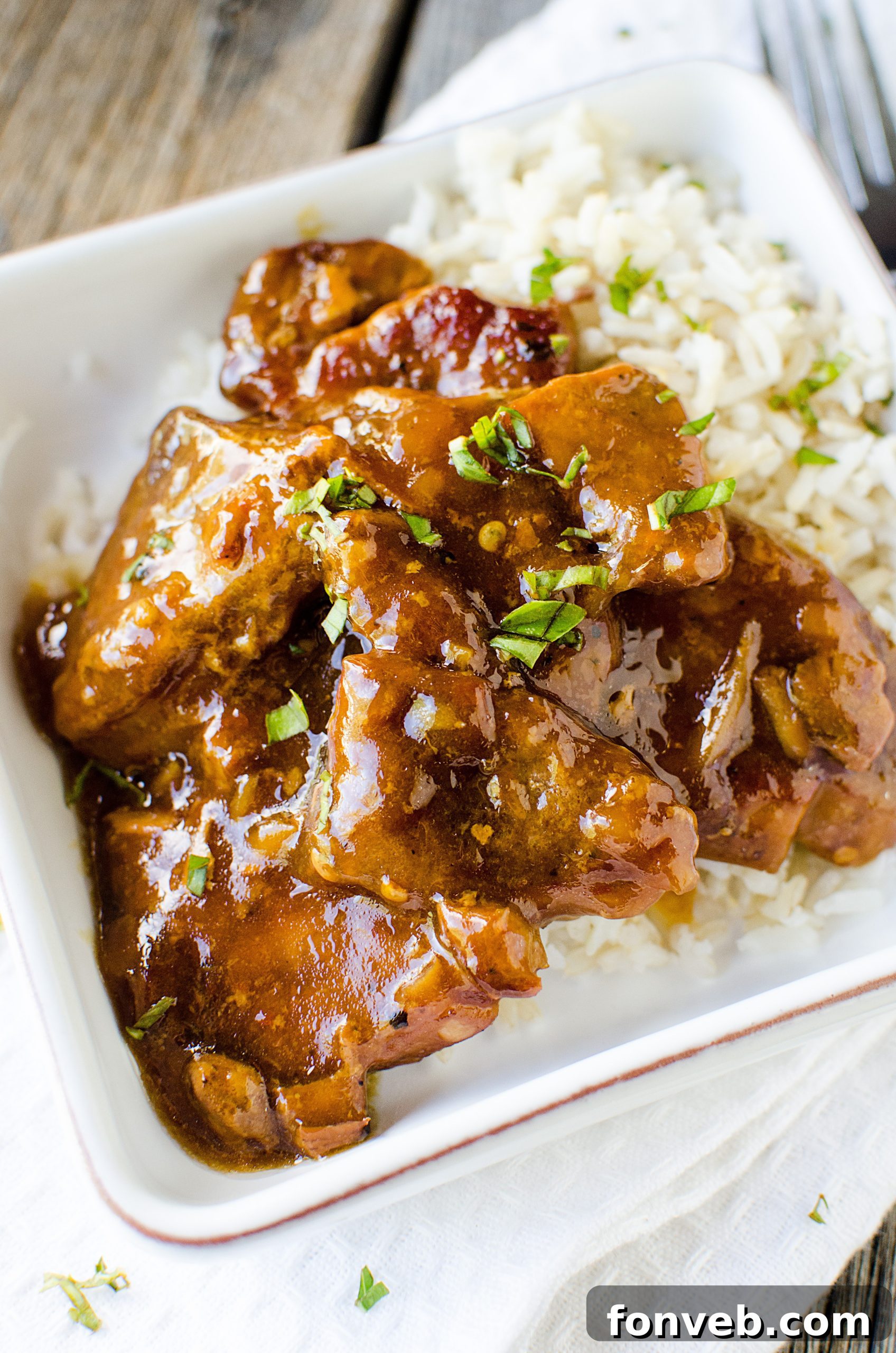 Tender Garlic Ginger Slow Cooker Pork 10 Slow Cooker Garlic Ginger Pork served perfectly over a bed of fluffy white rice.