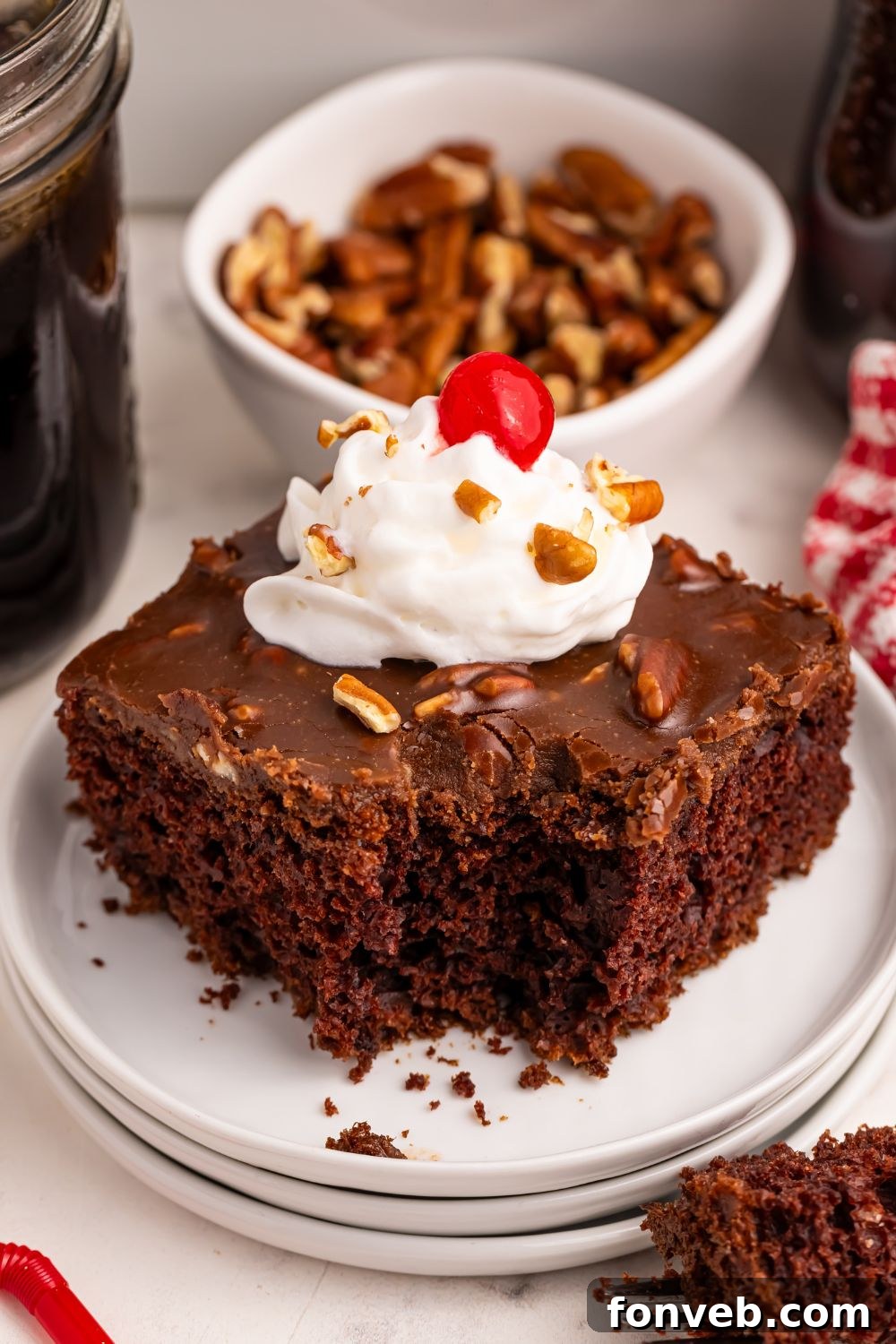 Classic Dr. Pepper Cake 18 A delectable slice of Dr. Pepper Cake, beautifully presented on a plate with a generous topping of whipped cream and a cherry.