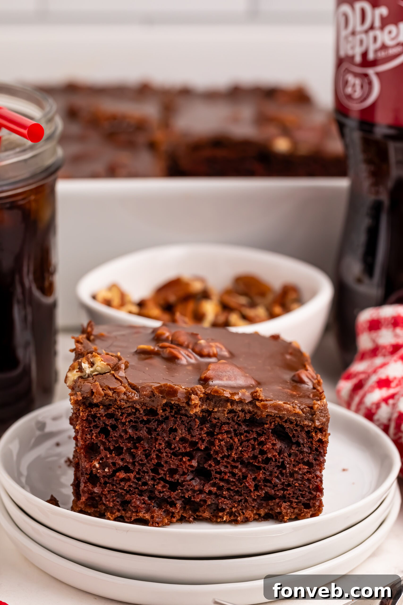 Classic Dr. Pepper Cake 21 A final close-up of a Dr. Pepper Cake slice on a plate, with a bowl of walnuts in the background, inviting viewers to savor the rich flavors.