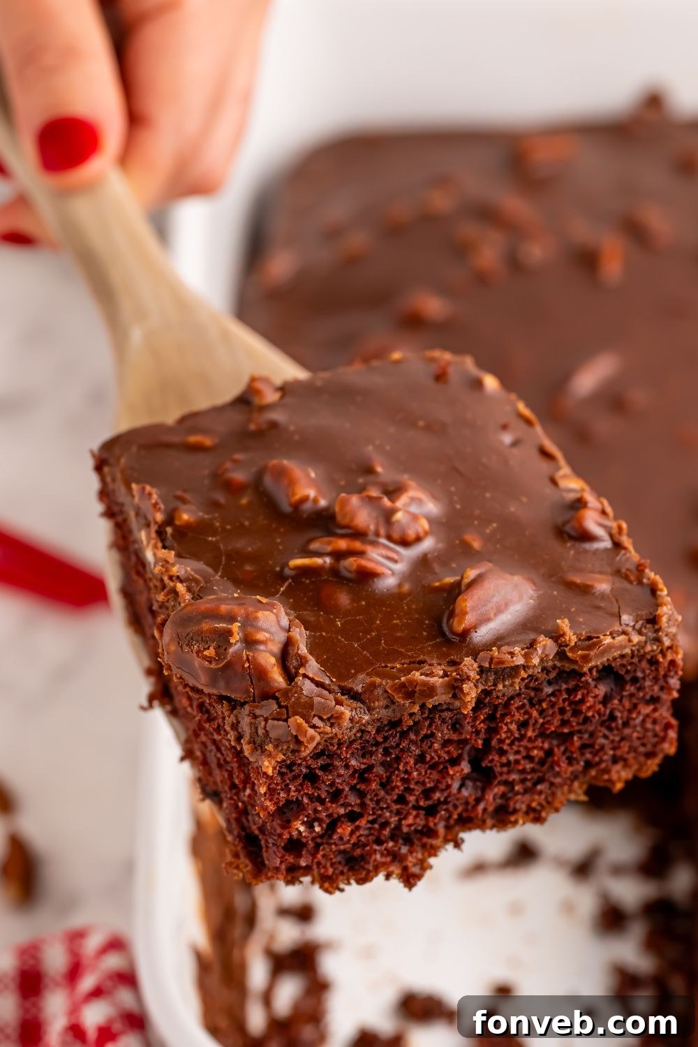 Classic Dr. Pepper Cake 4 A fresh Dr. Pepper Cake cooling in a baking pan, with a spatula lifting out a perfect, glazed slice, ready to be served.