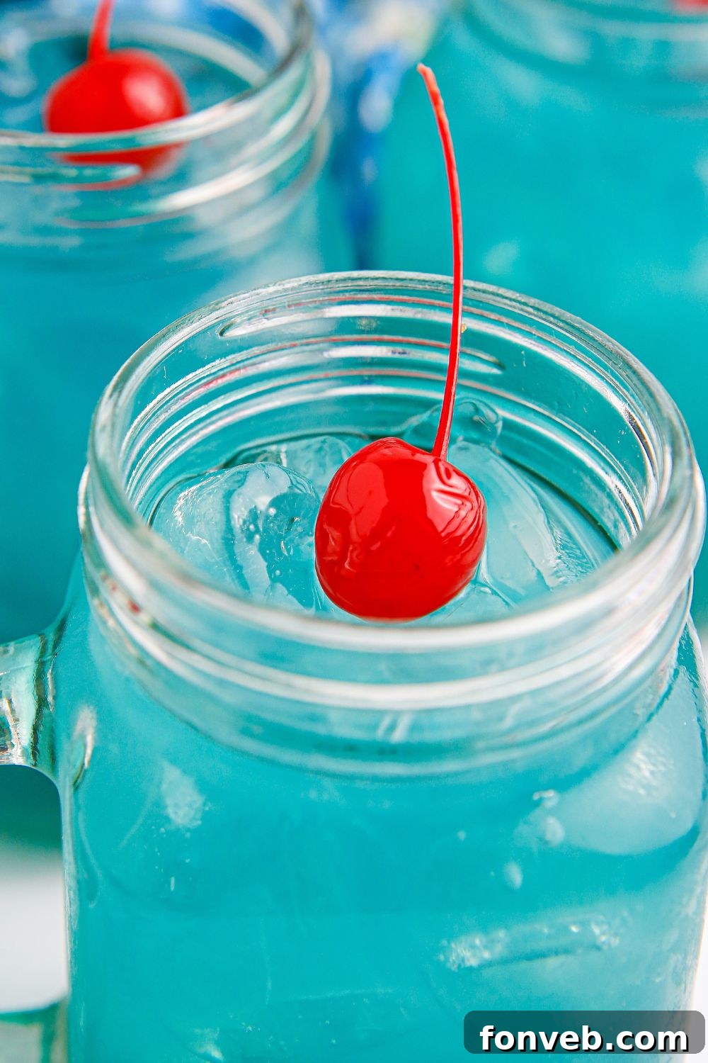 Glasses of Blue Hawaiian Punch, elegantly presented with stemmed cherries, ready to be enjoyed.