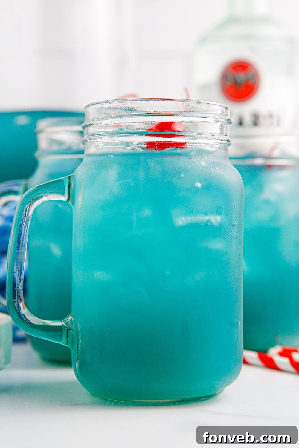 A close-up of a glass filled with Blue Hawaiian Punch, resting on a table, highlighting its refreshing texture.