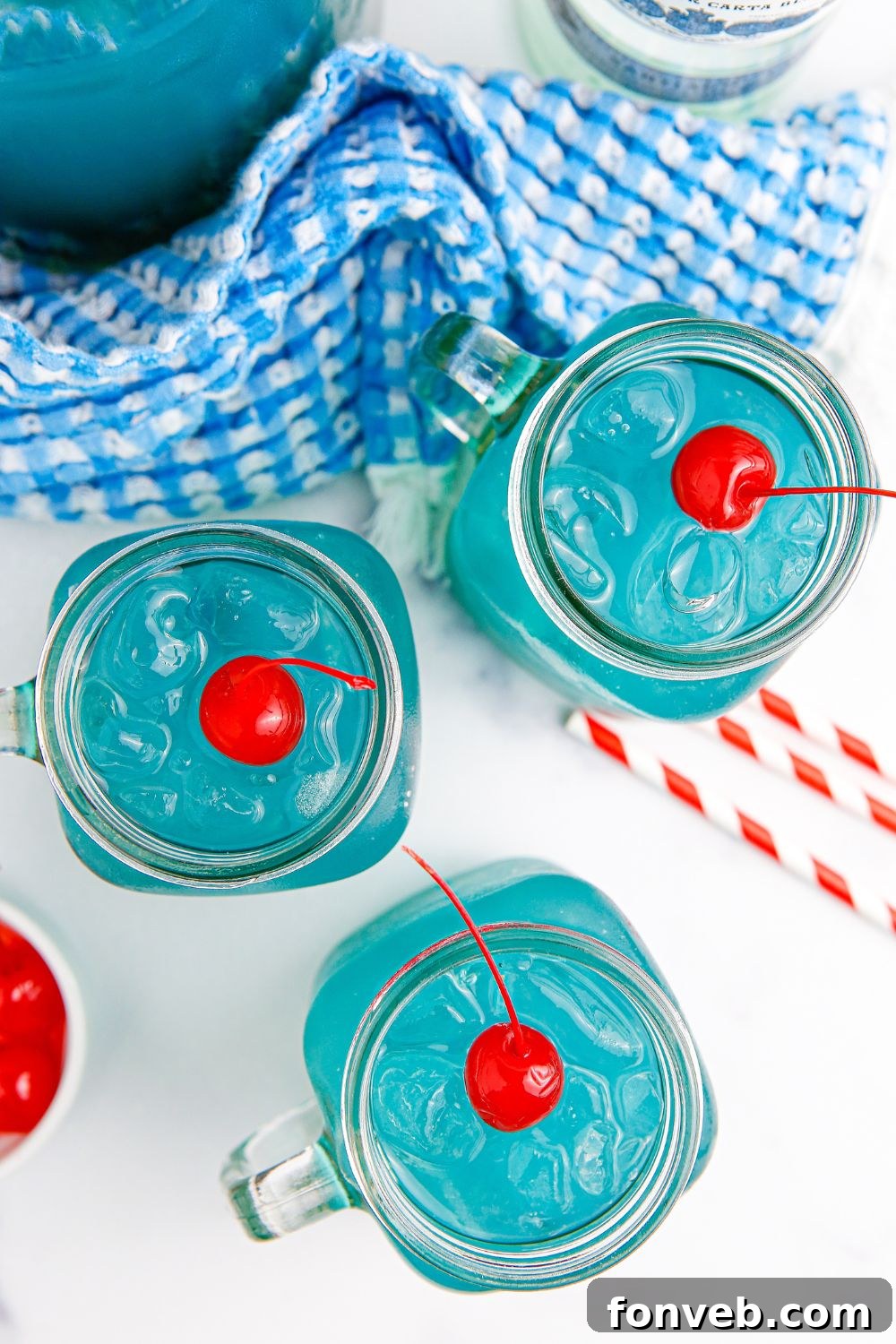 Glasses of Blue Hawaiian Punch arranged on a table, inviting guests to serve themselves.
