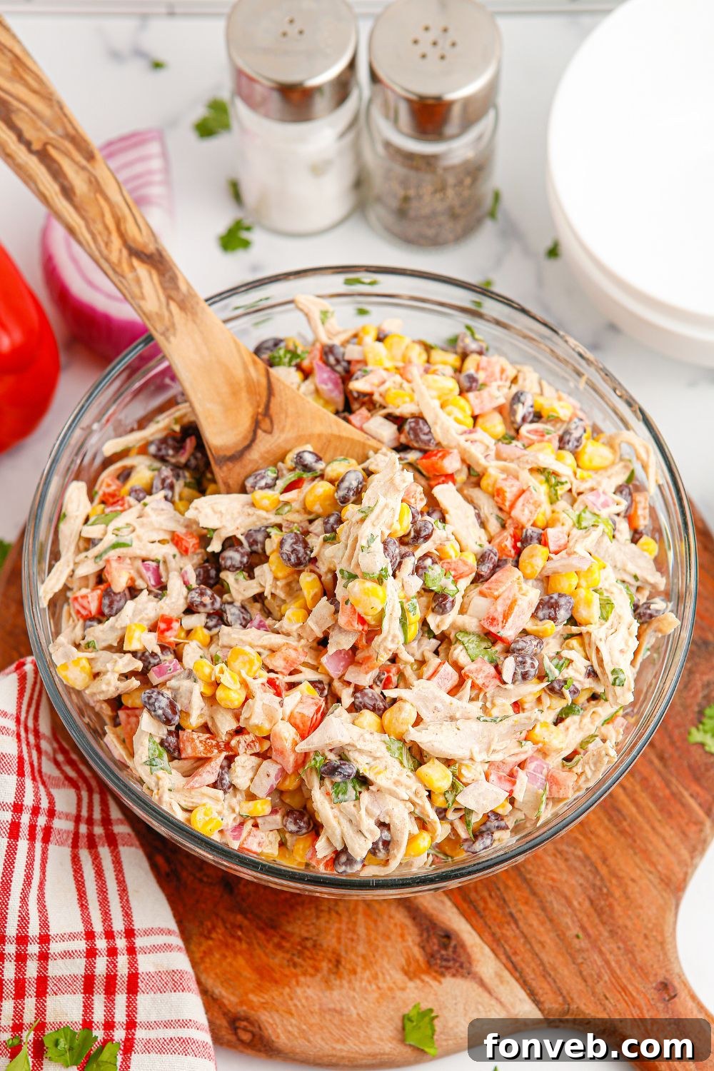 Southwestern Chicken Salad 18 A bowl of Southwest-style chicken salad on a table, accompanied by salt and pepper shakers, providing a cozy and inviting meal scene.