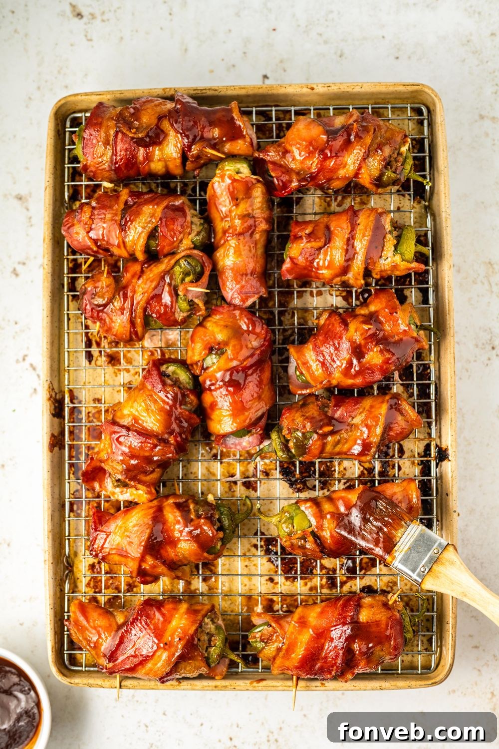 Texas Twinkies with bbq sauce being brushed over the top of the jalapeno twinkies