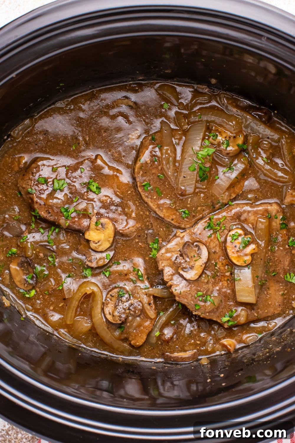 Slow Cooker Round Steak and Gravy overhead shot of steak smothered in gravy in slow cooker 
