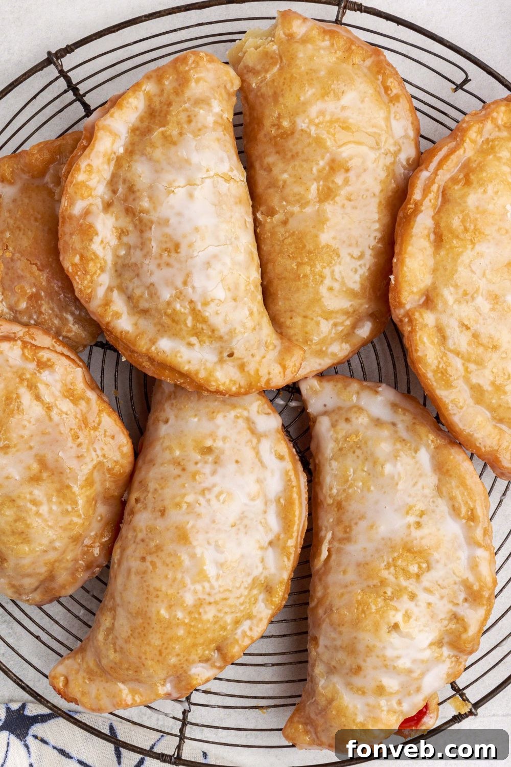 hand pies spread out on a cooling rack on marble counter top