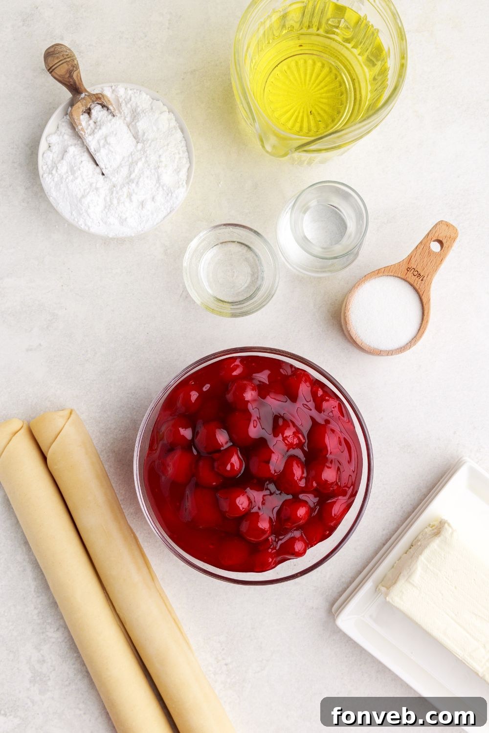 ingredients for Cherry Cheesecake Hand Pies in single serve containers on table to showcase each of the ingredients 