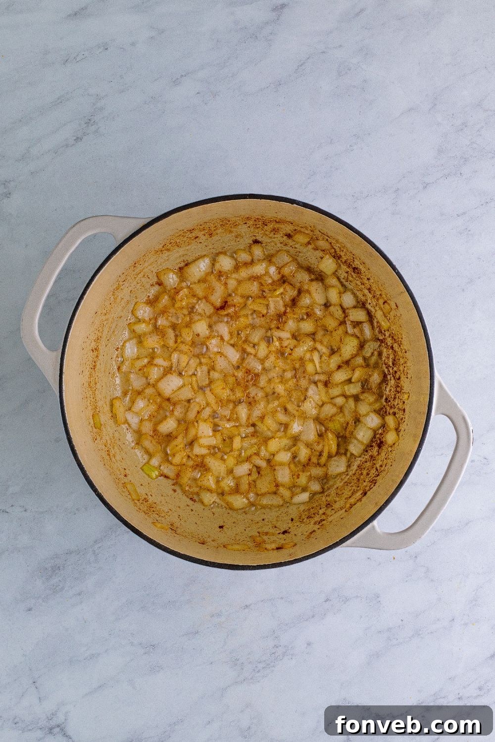 sauteed onions and garlic in a dutch oven sitting on a table 