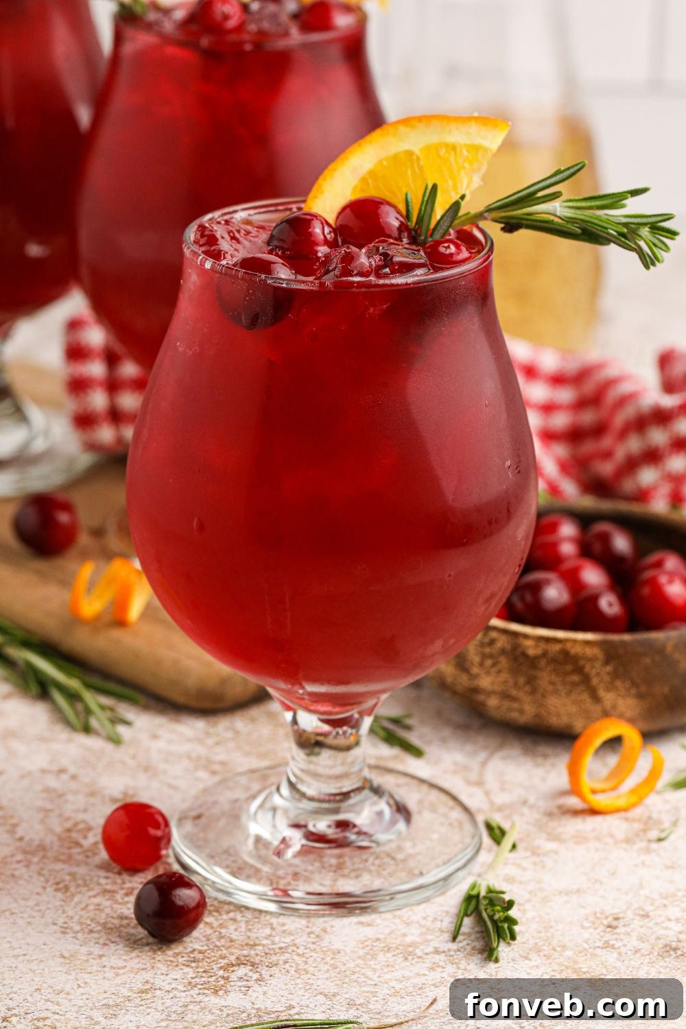 Crimson Whiskey Zing 5 Cranberry Whiskey Sour cocktails on the table with cranberries and orange garnish on the table