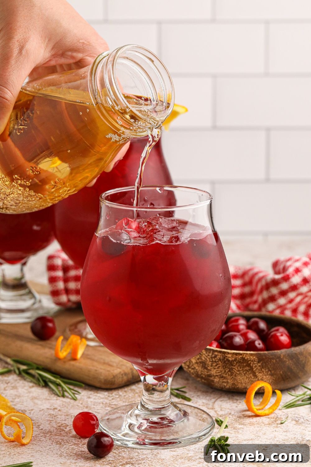 Crimson Whiskey Zing 8 pouring juice into a glass for making a cranberry cocktail