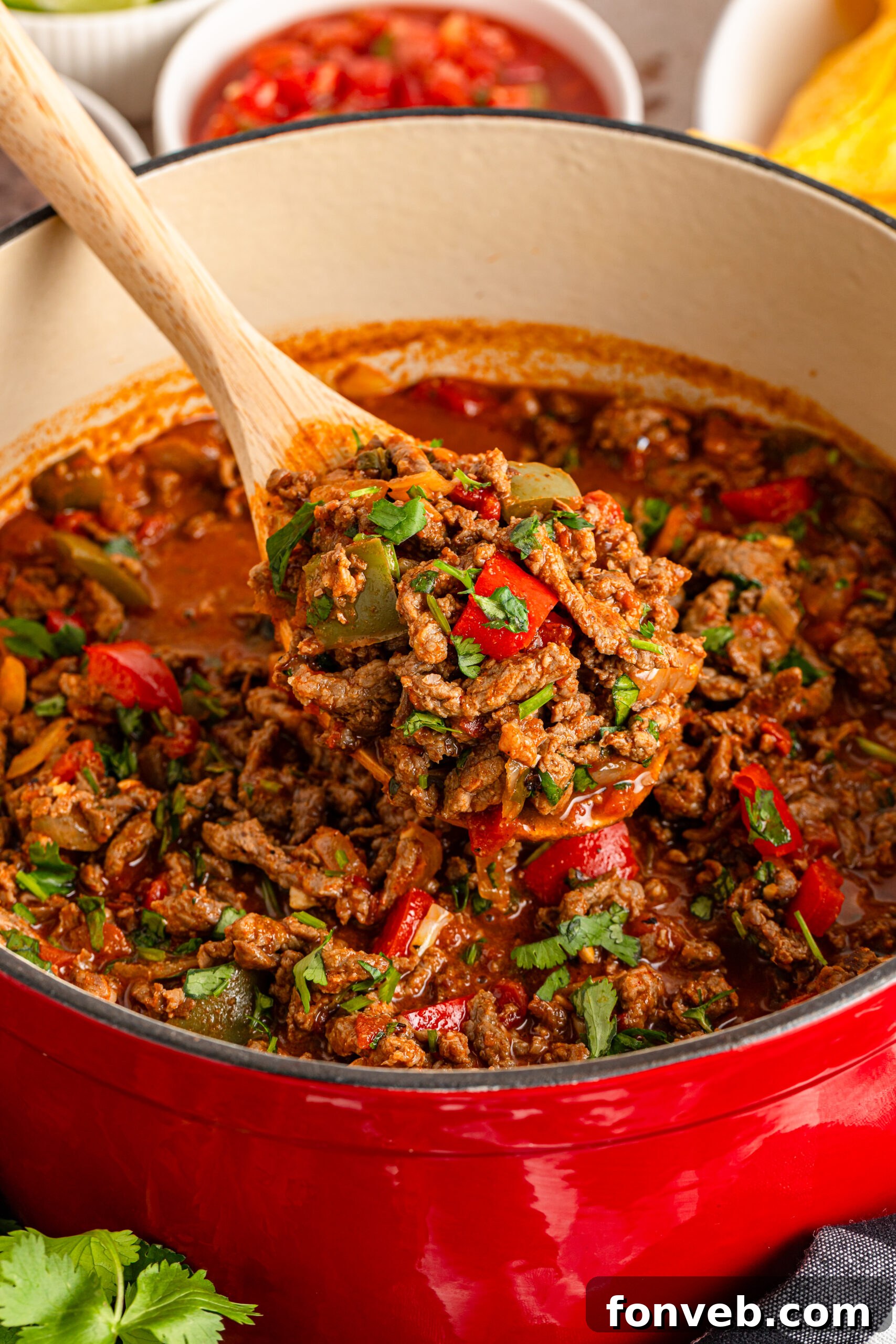 Zesty Ground Beef Medley 2 Rich Carne Picada simmering in a dutch oven, being stirred with a wooden spoon to show texture and steam