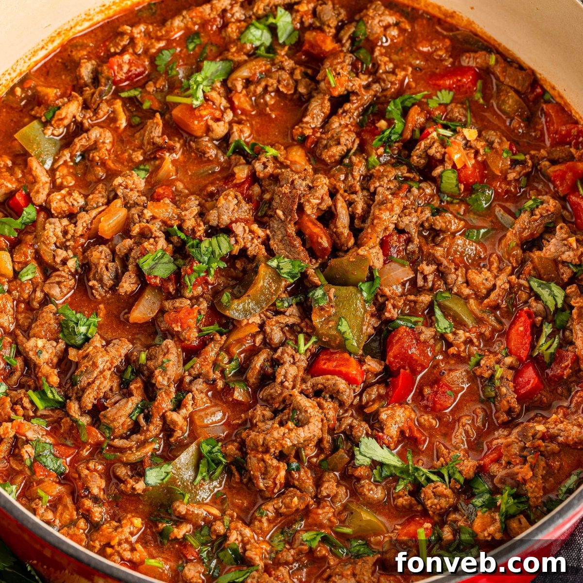 Zesty Ground Beef Medley 3 Carne Picada in a traditional Dutch oven, showcasing tender beef chunks, bell peppers, and onions simmered in a rich sauce