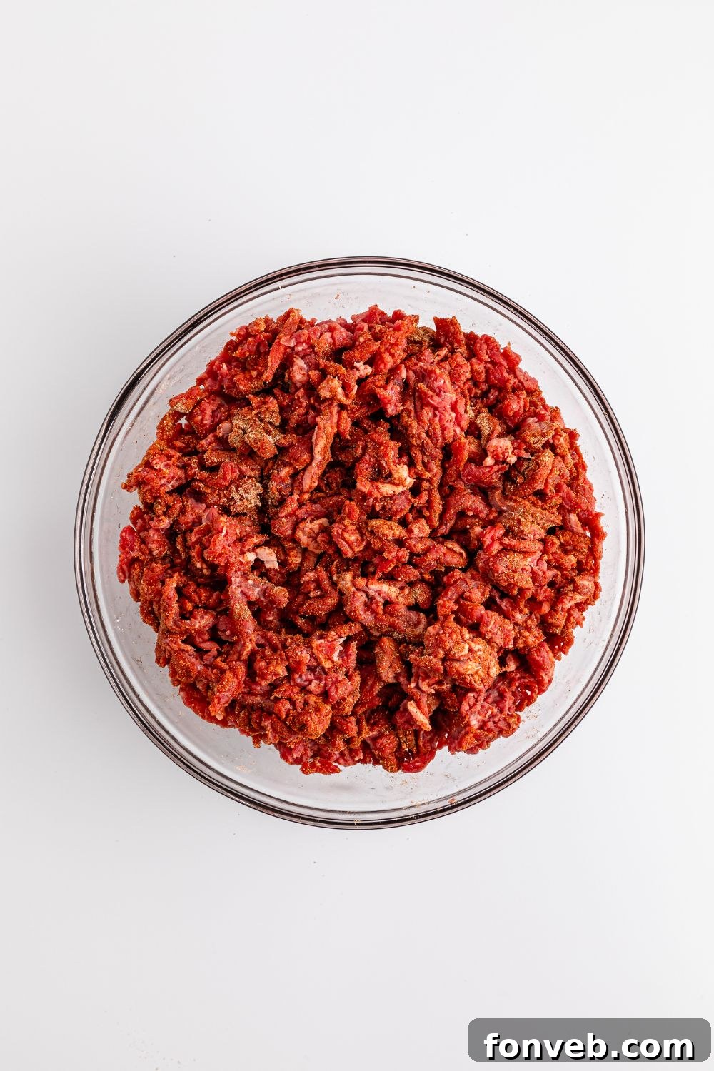 Zesty Ground Beef Medley 8 Seasoned chopped beef pieces in a clear glass bowl, coated in a spice mixture, ready for cooking