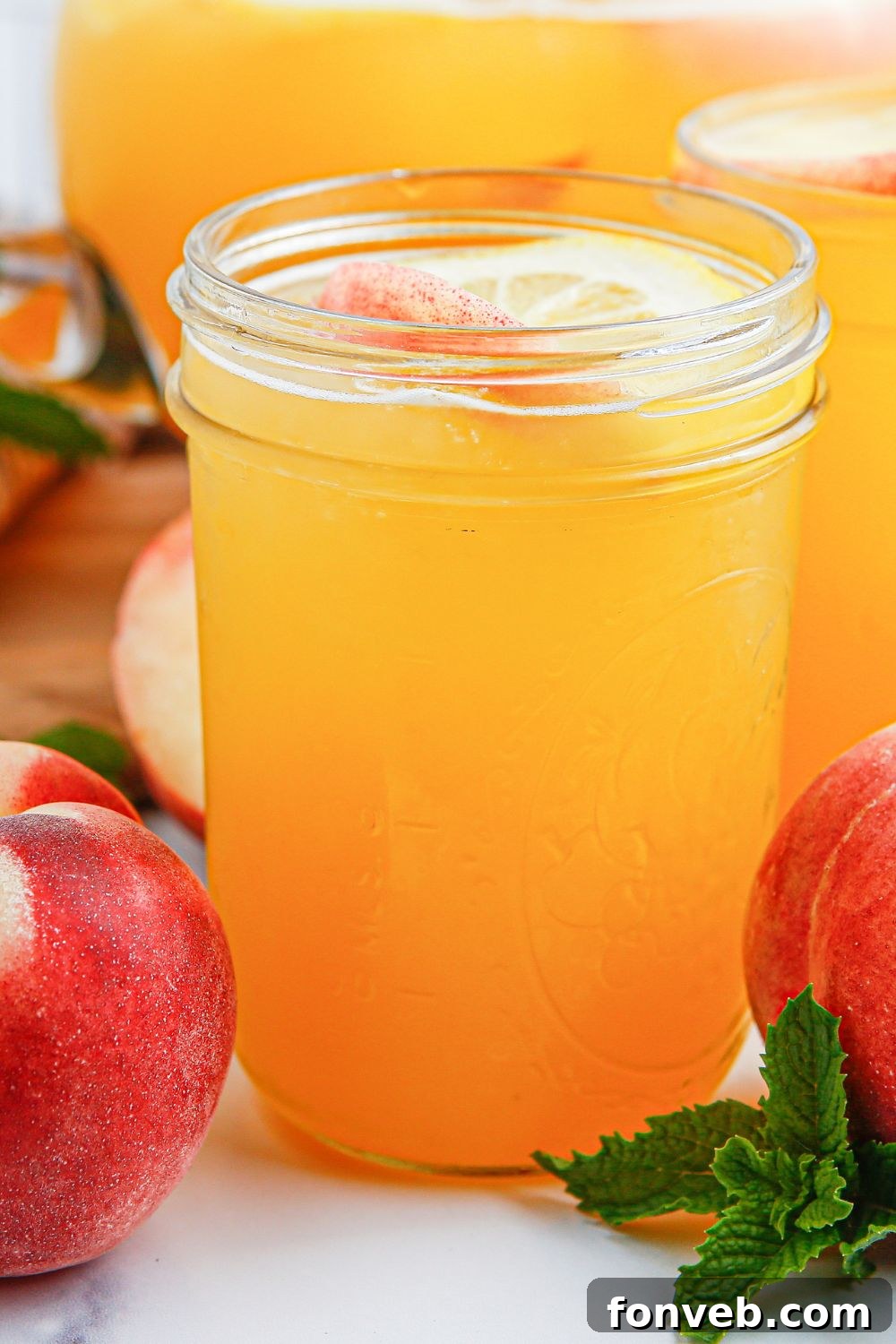 Sun-Kissed Peach Lemonade 13 fresh peach lemonade in mason jar glasses sitting on table