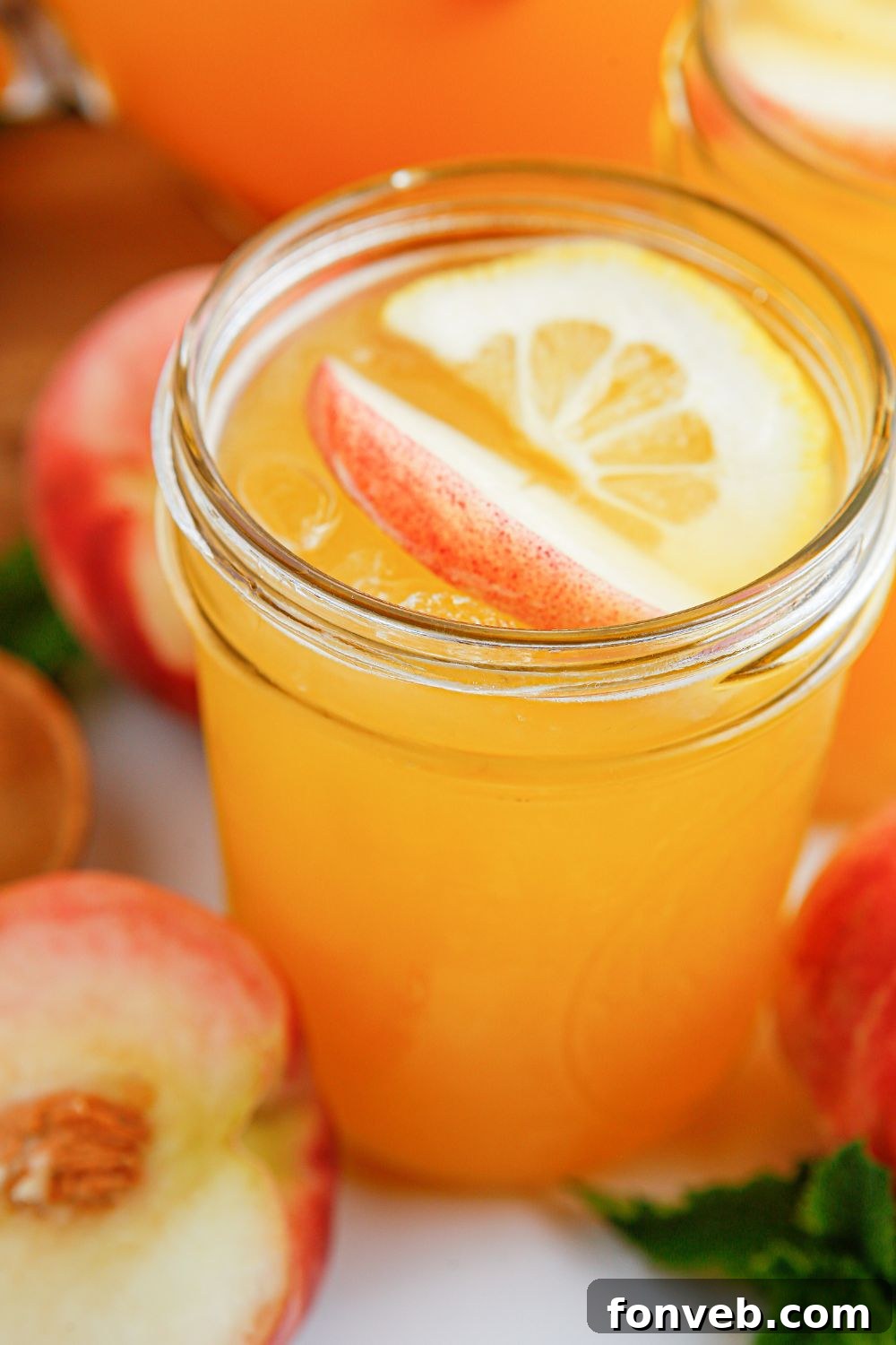Sun-Kissed Peach Lemonade 15 Peach Lemonade in glasses with fresh fruit all around it