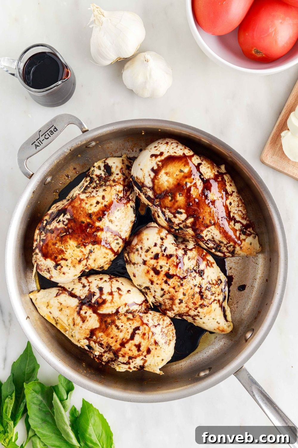 Balsamic glaze poured on top of Caprese Stuffed Chicken in a pan, adding flavor and sheen