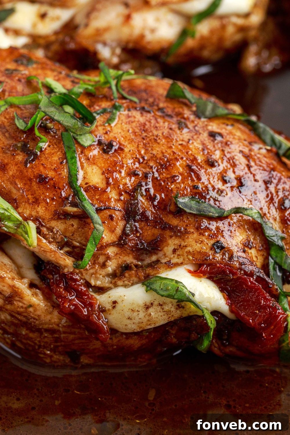 Caprese Stuffed Chicken on a plate, showcasing the fresh herbs on top and a generous drizzle of balsamic glaze