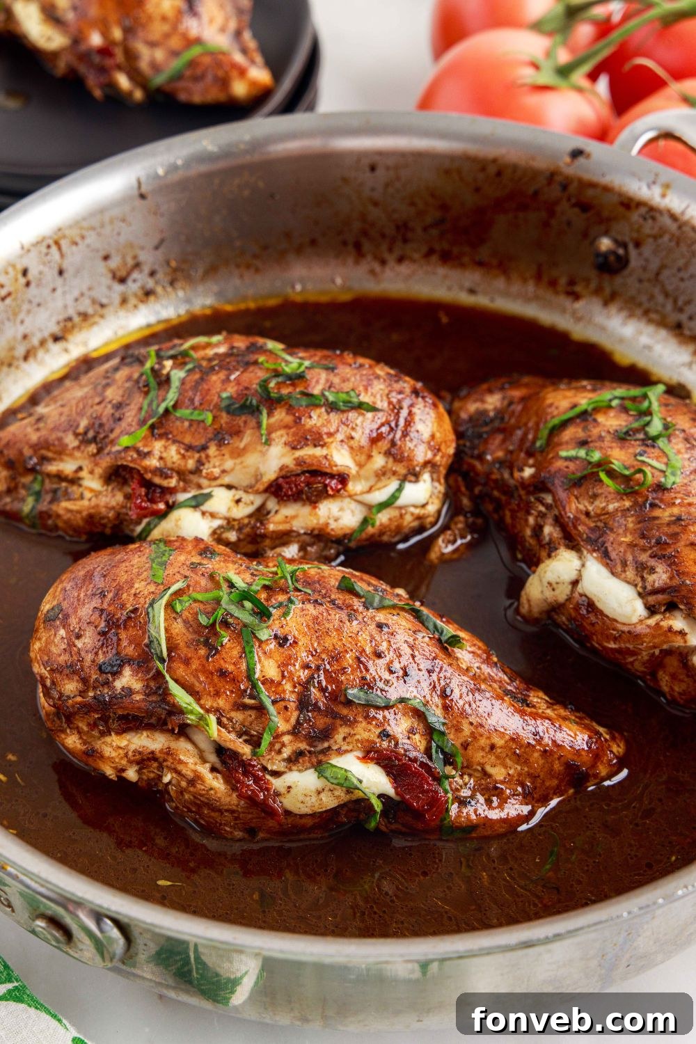 Caprese Stuffed Chicken in a skillet with the savory sauce still in the pan, ready to be drizzled