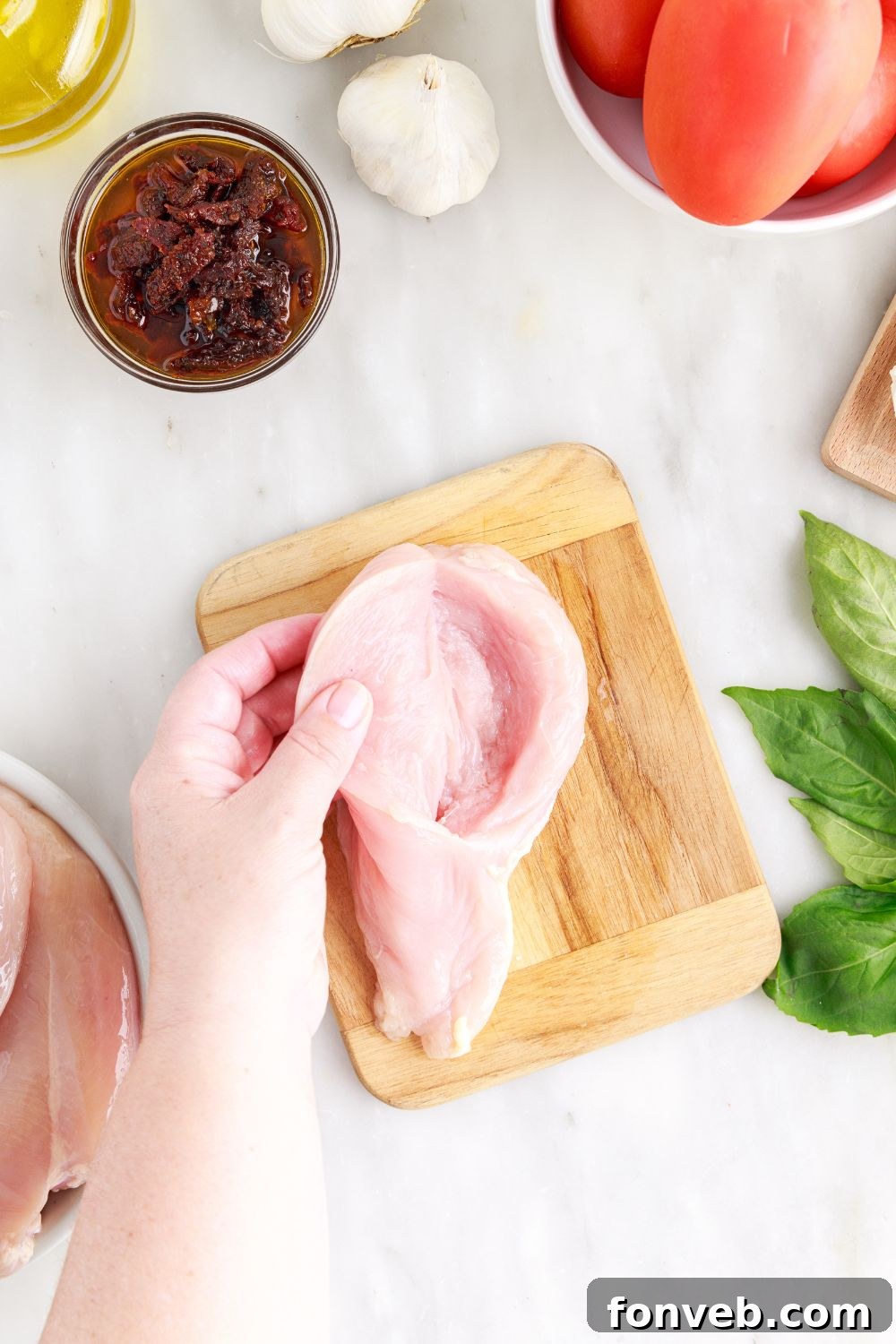 Opening up the raw chicken to show the butterfly center, ready for stuffing